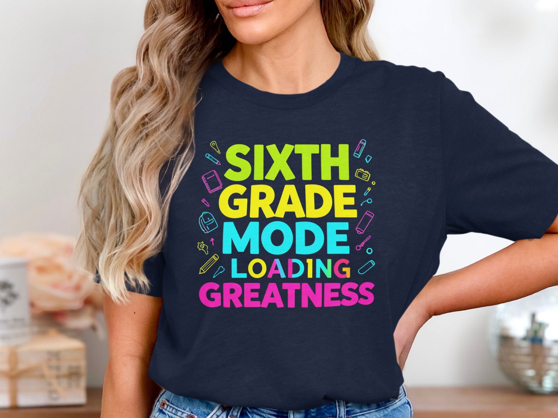 Sixth Grade Mode Loading Greatness t-shirt with school supplies graphic.
