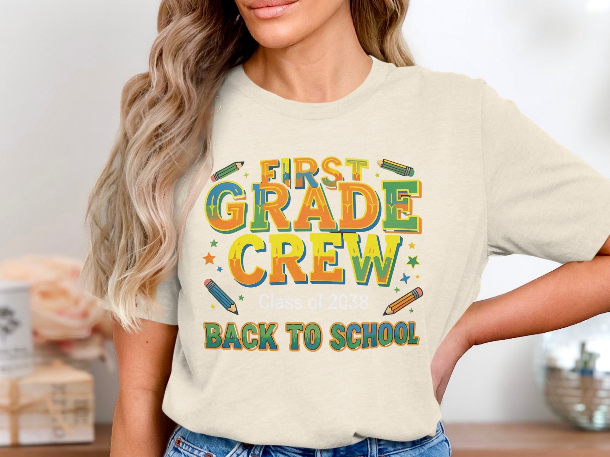 "First Grade Crew Class of 2038 Back to School" shirt with colorful pencils and stars.