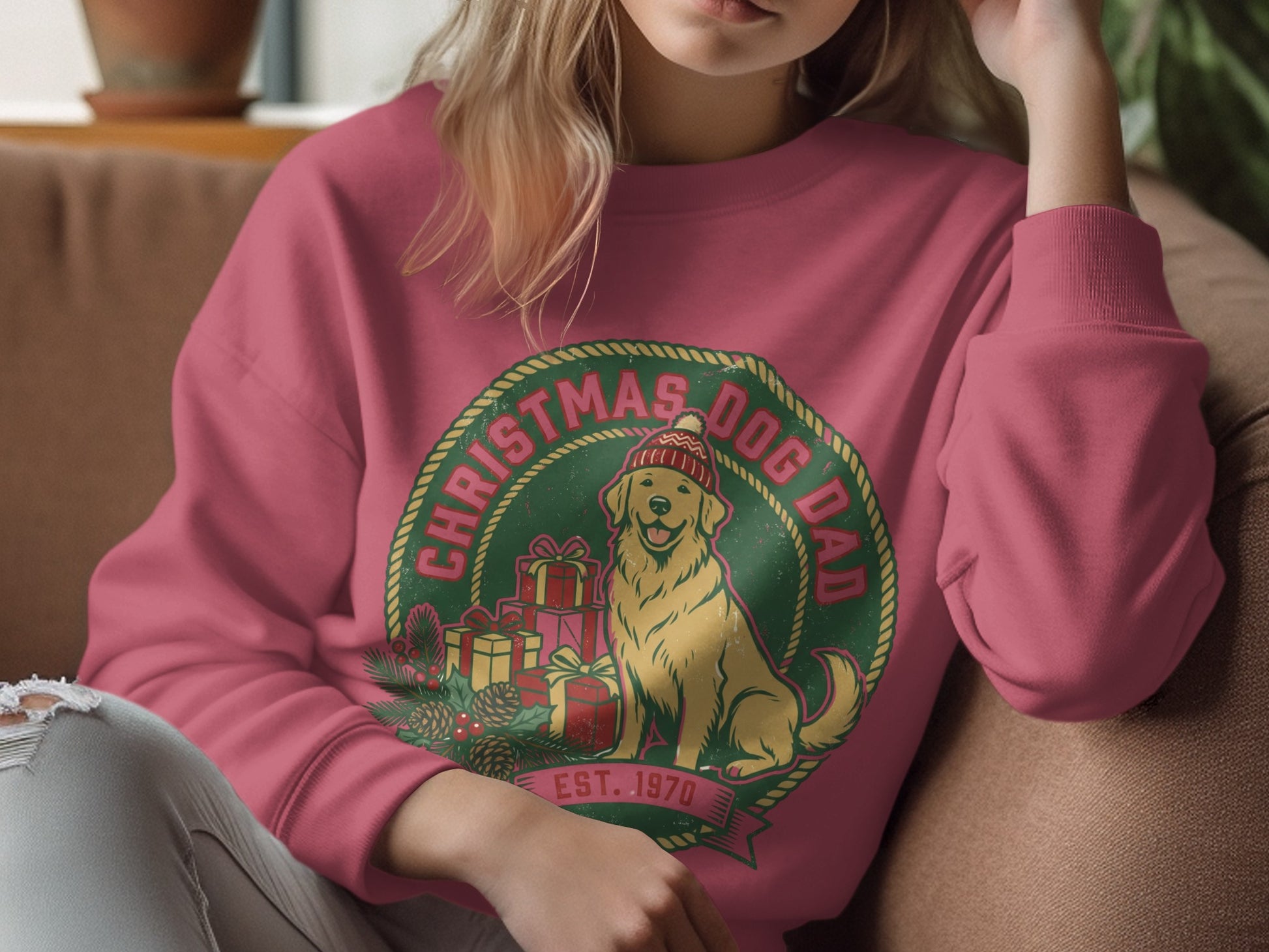 Christmas Dog Dad graphic on a pink sweatshirt with a golden retriever, presents, and pinecones.