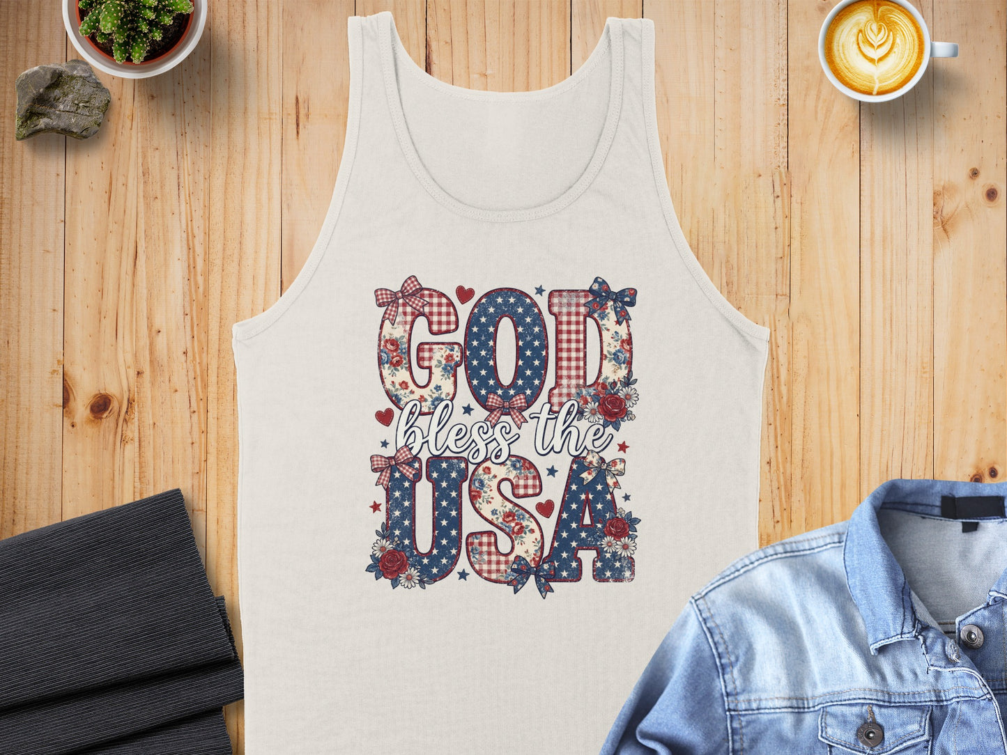 Cream tank top with "God bless the USA" text in patriotic patterns.