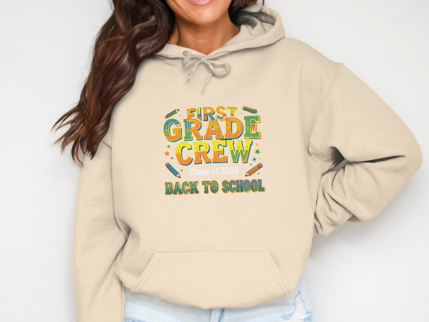 Cream hoodie with "First Grade Crew Class of 2038 Back to School" text and colorful graphics.
