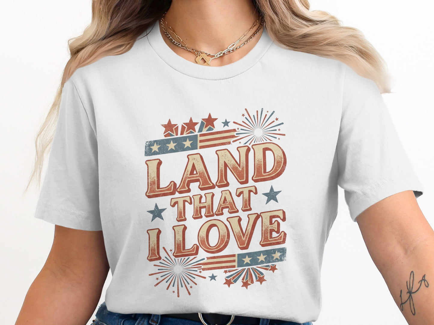 White t-shirt with "LAND THAT I LOVE" text and patriotic fireworks graphic.
