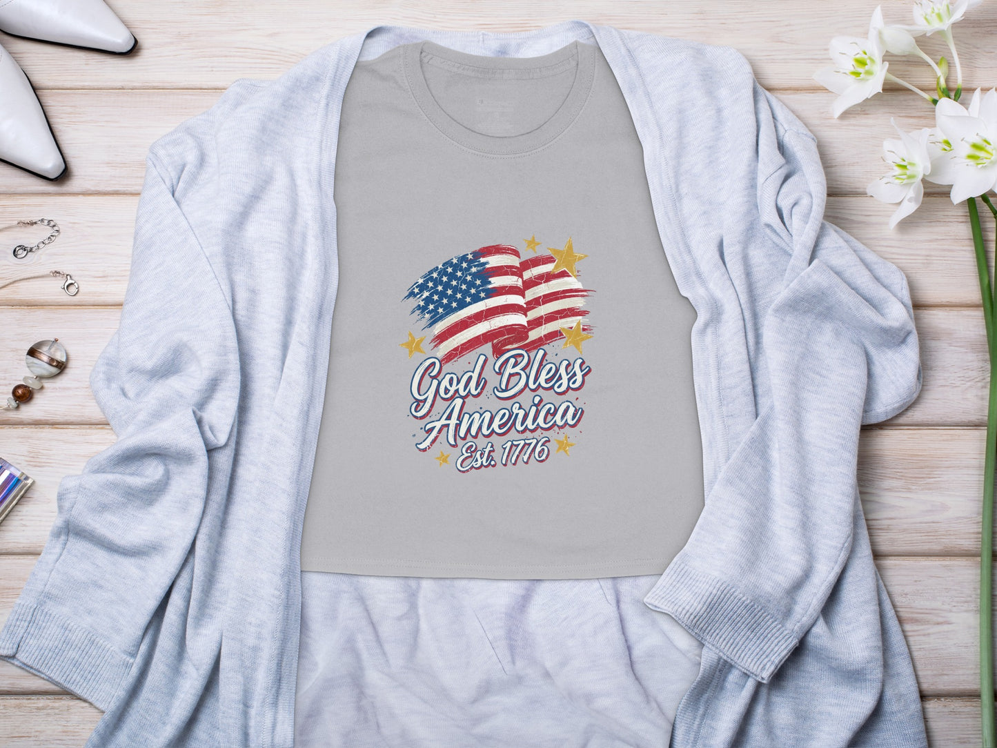 Grey t-shirt with distressed American flag and "God Bless America Est. 1776" text.