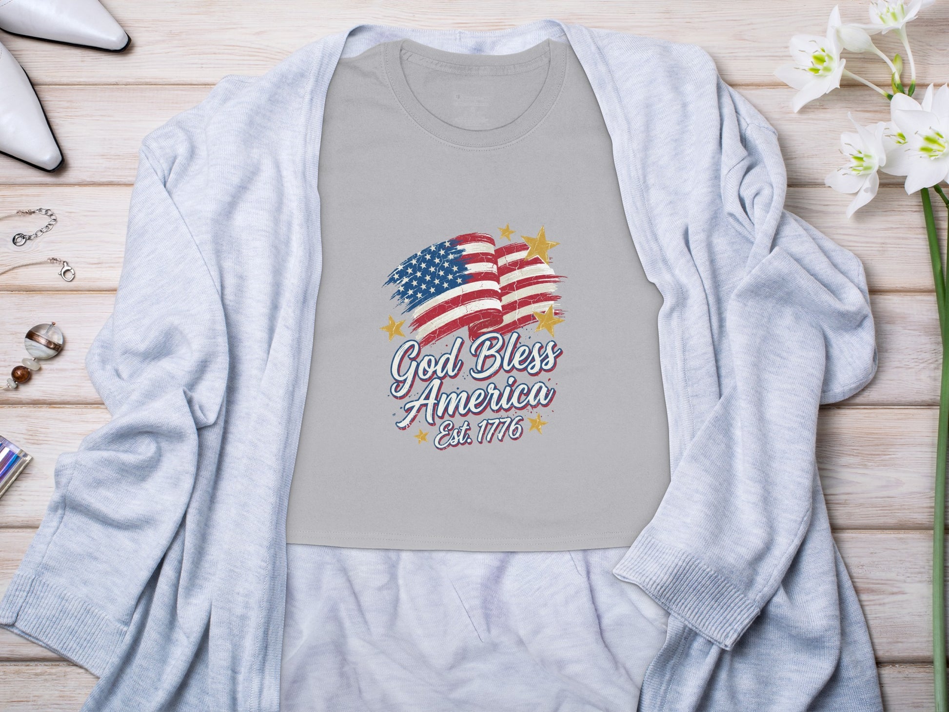 Grey t-shirt with distressed American flag and "God Bless America Est. 1776" text.