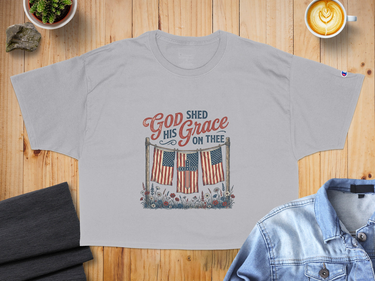 Grey t-shirt with American flags, a cross, and "God Shed His Grace On Thee" text.