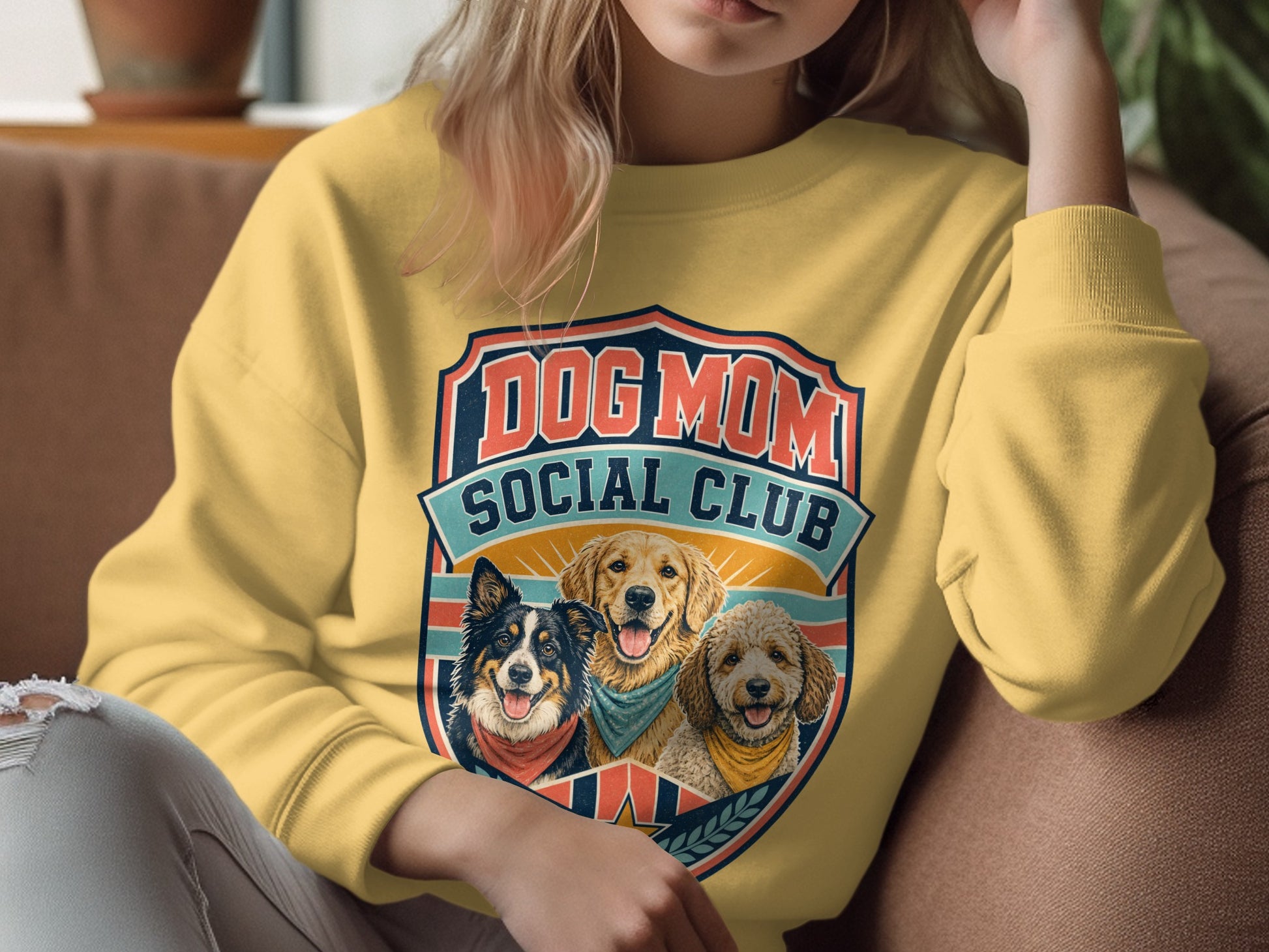 Yellow sweatshirt with a "Dog Mom Social Club" graphic featuring three dogs.