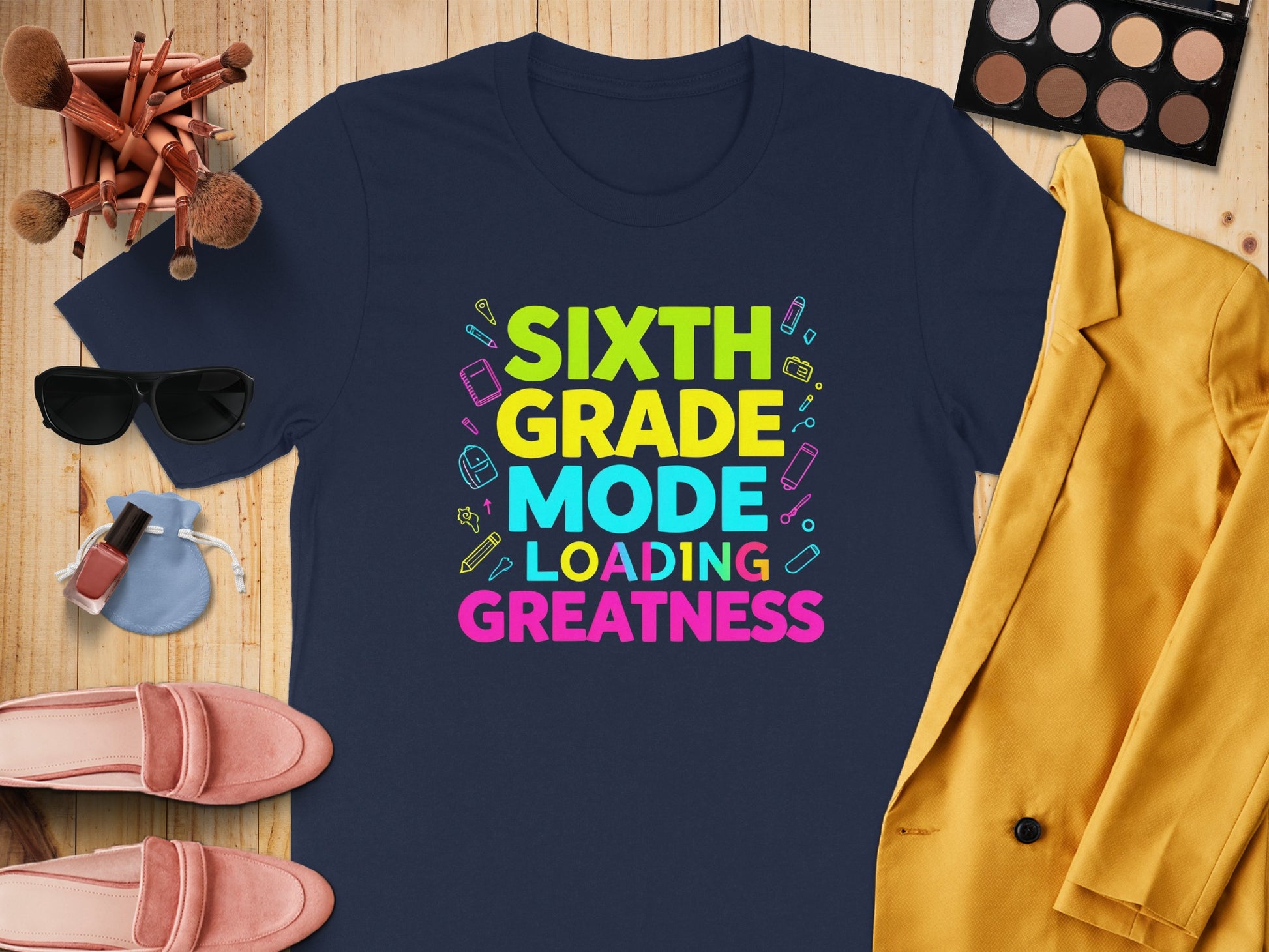 Navy t-shirt with text "SIXTH GRADE MODE LOADING GREATNESS" and school supplies.