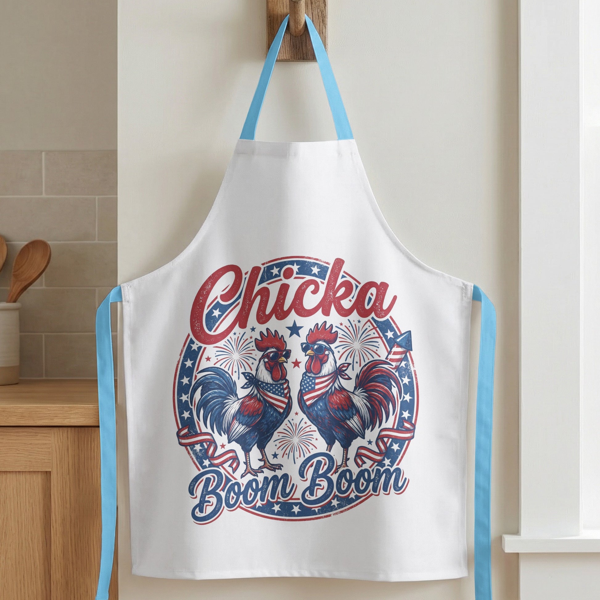 White apron with two roosters wearing sunglasses and bandanas, with text "Chicka Boom Boom".
