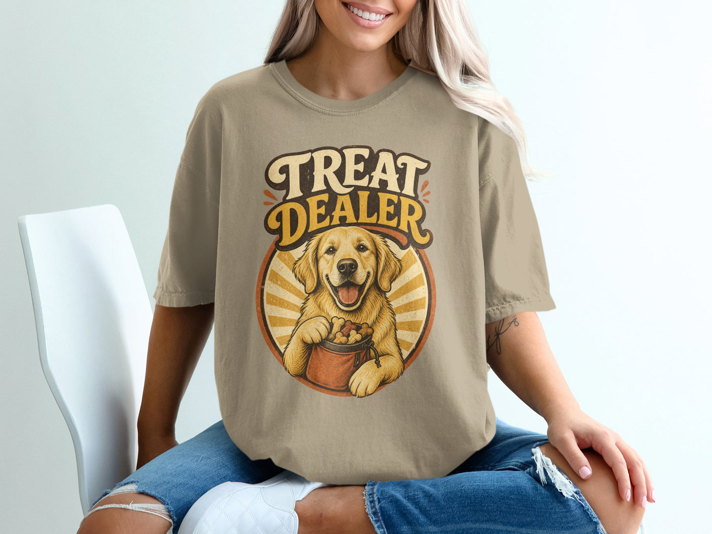 Golden Retriever holding bucket of treats with "Treat Dealer" text on beige t-shirt.