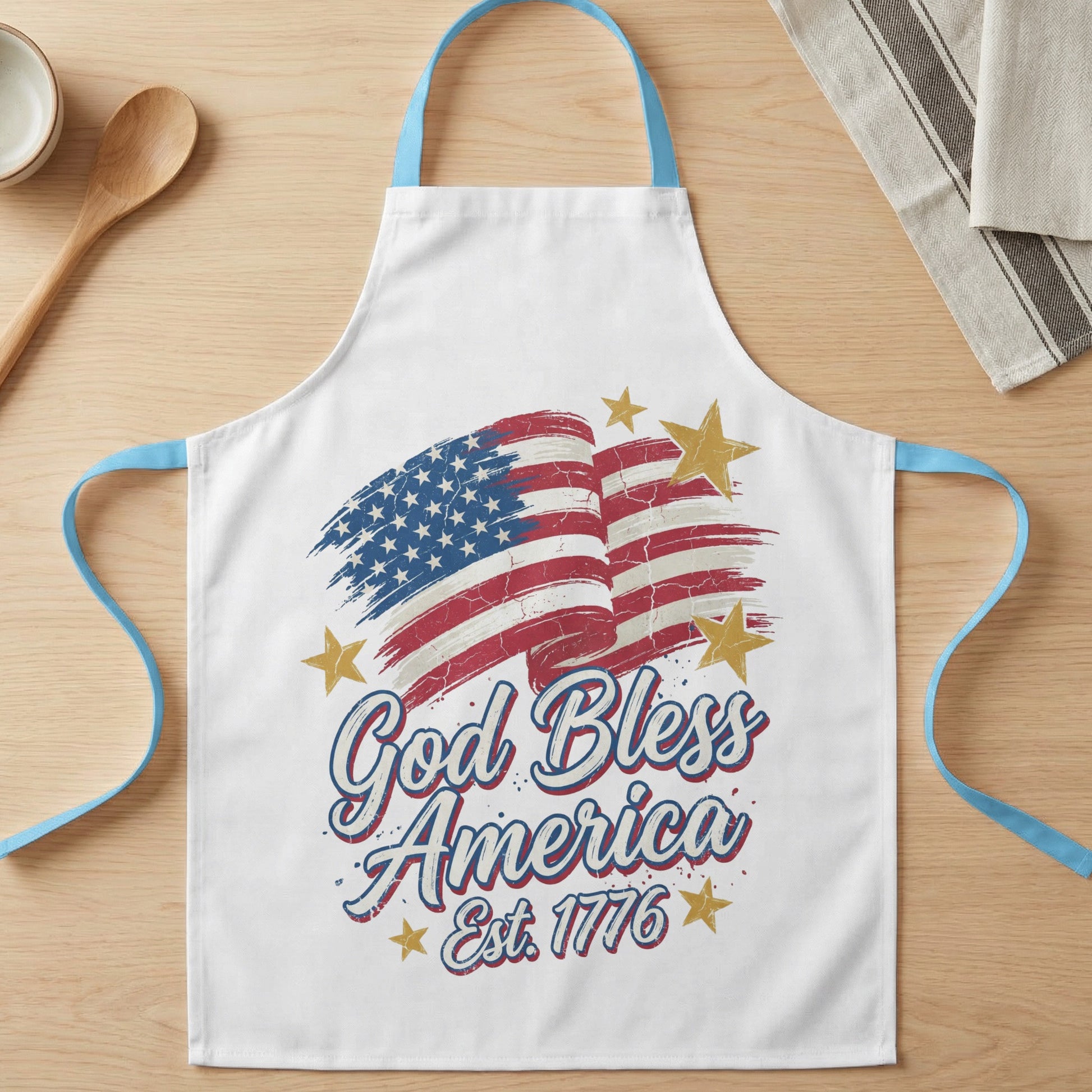 White apron with distressed American flag and "God Bless America Est. 1776" text.
