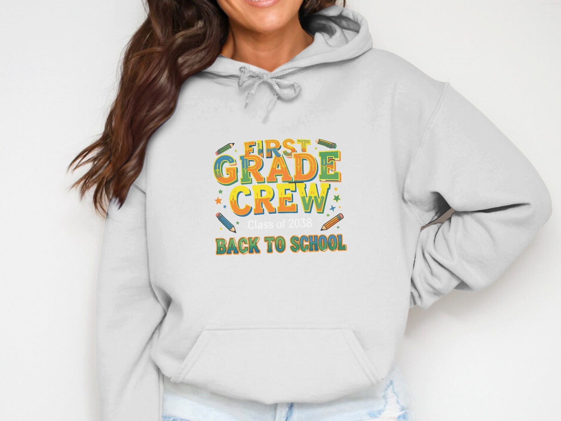White hoodie with "First Grade Crew Class of 2038 Back to School" text graphic.