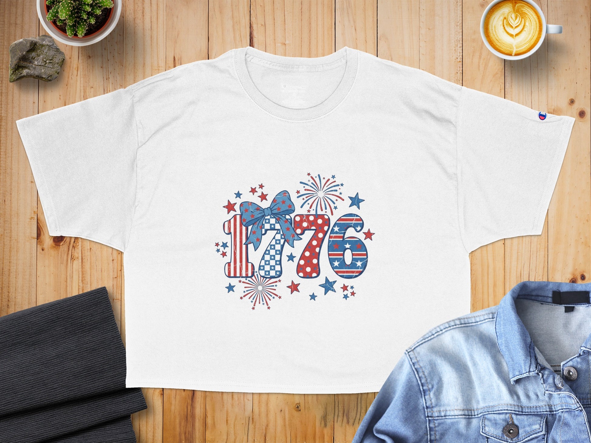 White t-shirt with patriotic "1776" graphic including fireworks and stars.