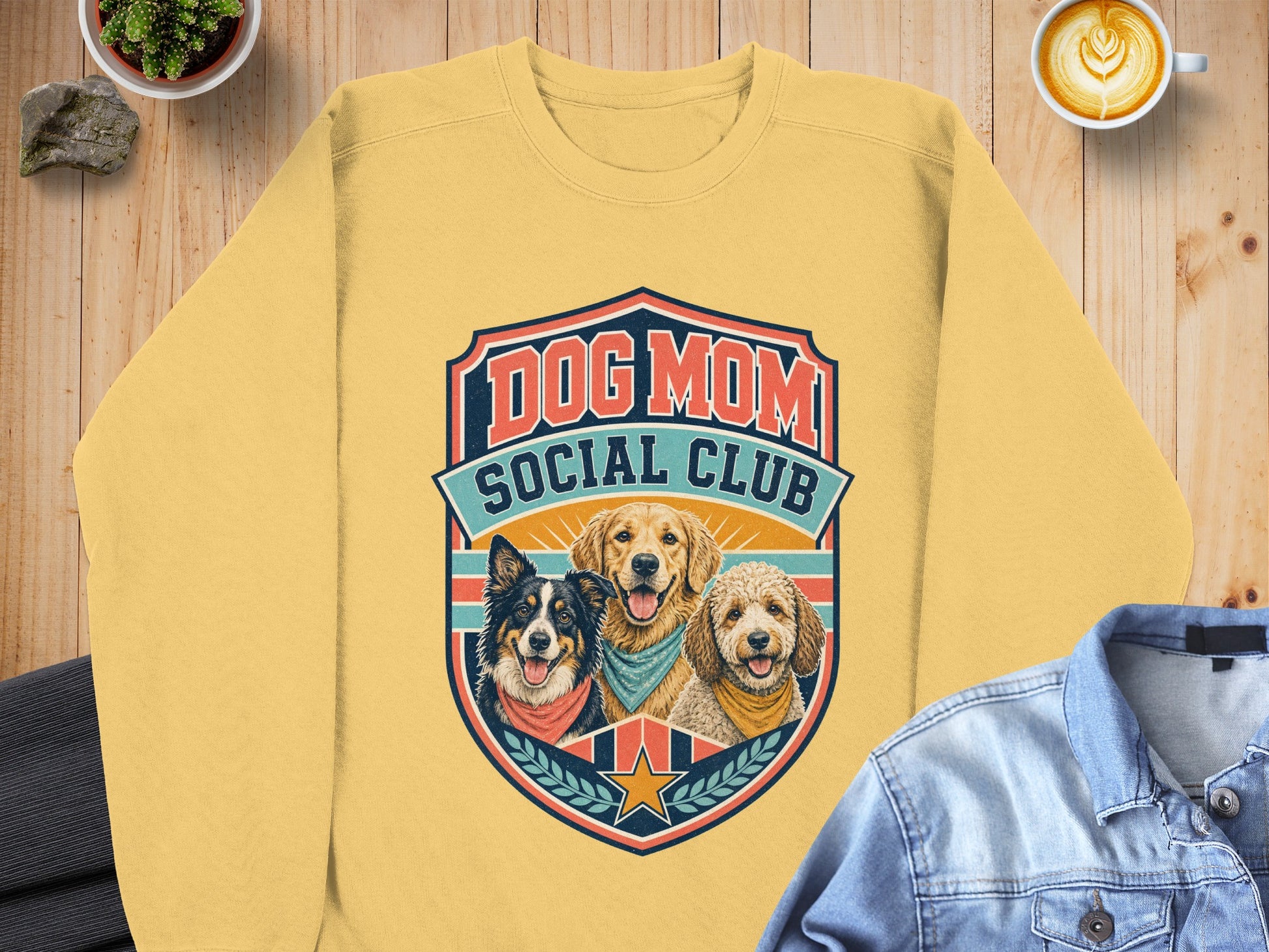 Yellow sweatshirt with "Dog Mom Social Club" and three dogs on a shield.