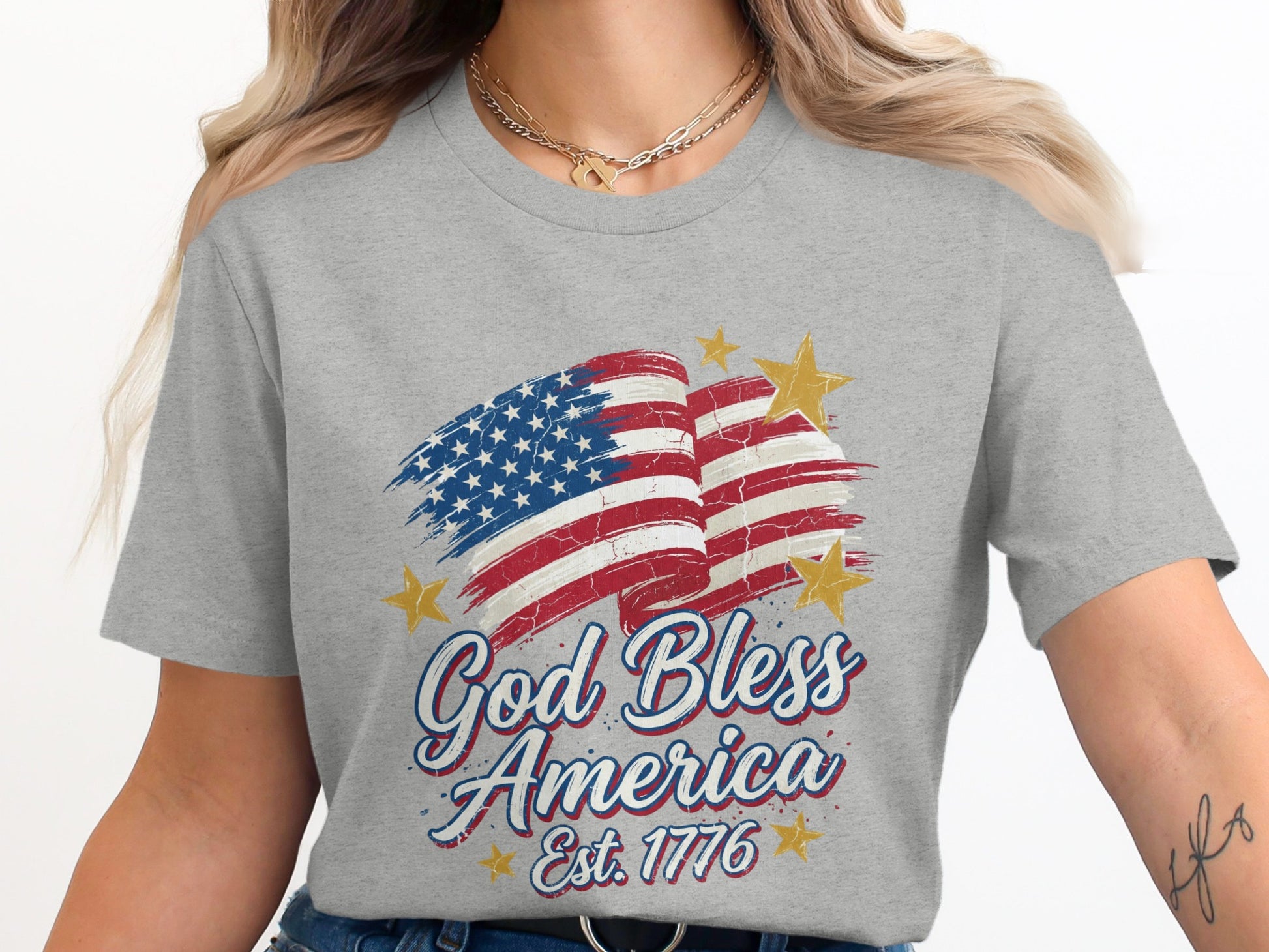 Gray t-shirt with distressed American flag and "God Bless America Est. 1776" text.