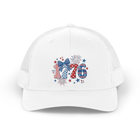 White mesh trucker hat with patriotic 1776 graphic featuring fireworks and a bow.