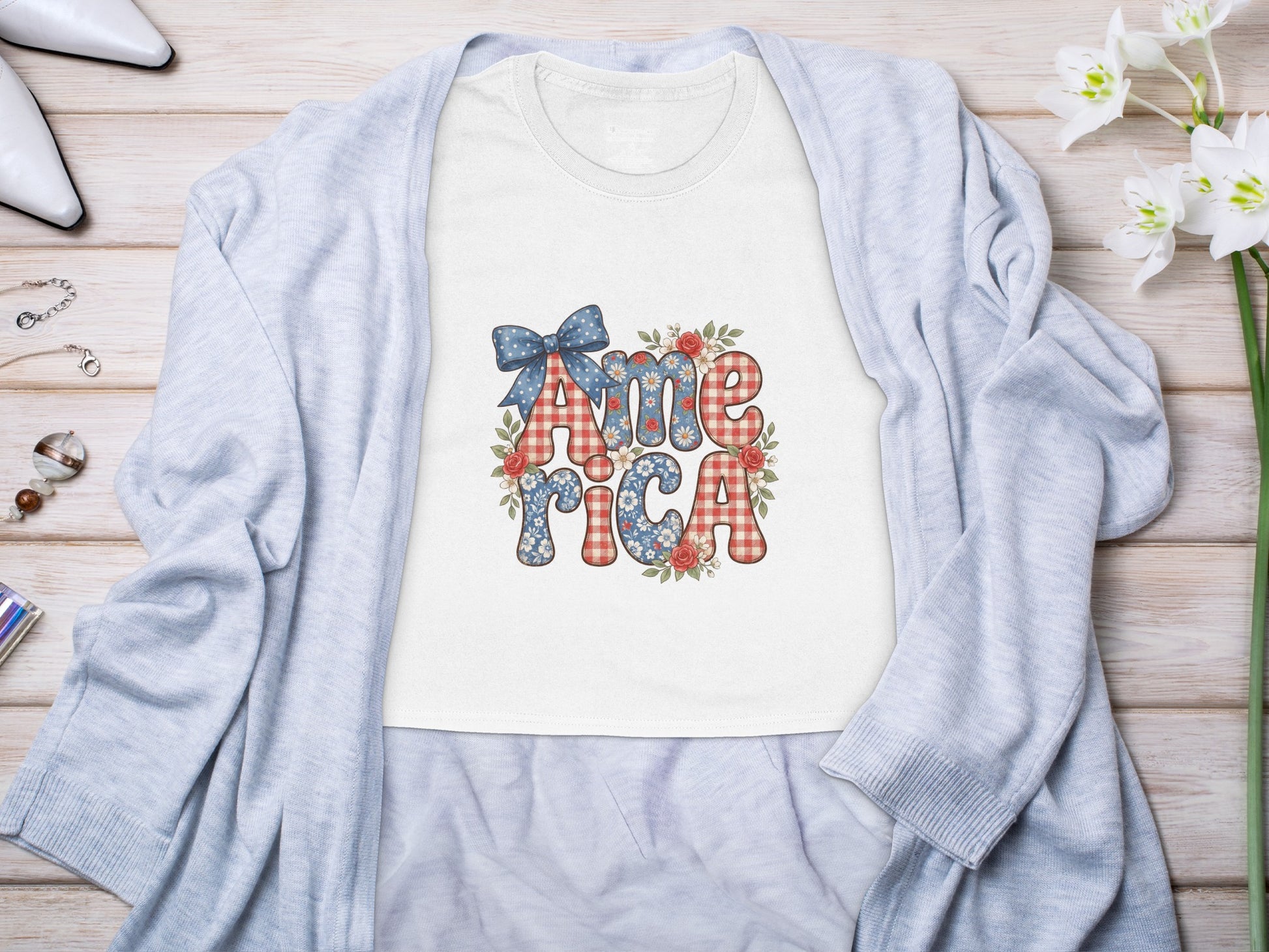 White t-shirt with "America" in patriotic patterned text and floral accents.