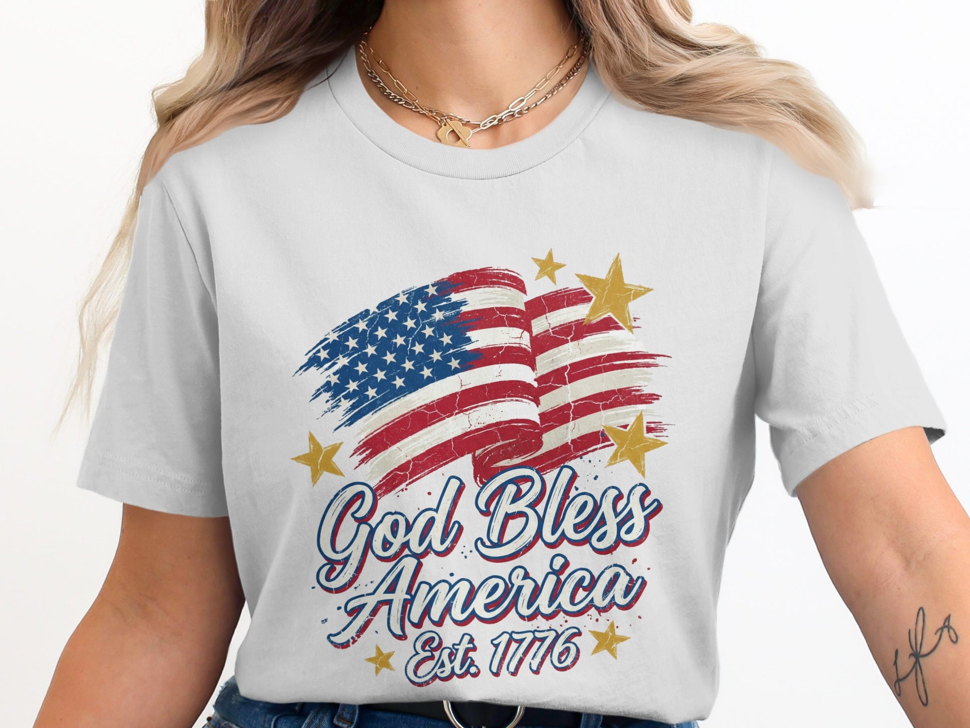 White t-shirt with distressed American flag and "God Bless America Est. 1776" text.