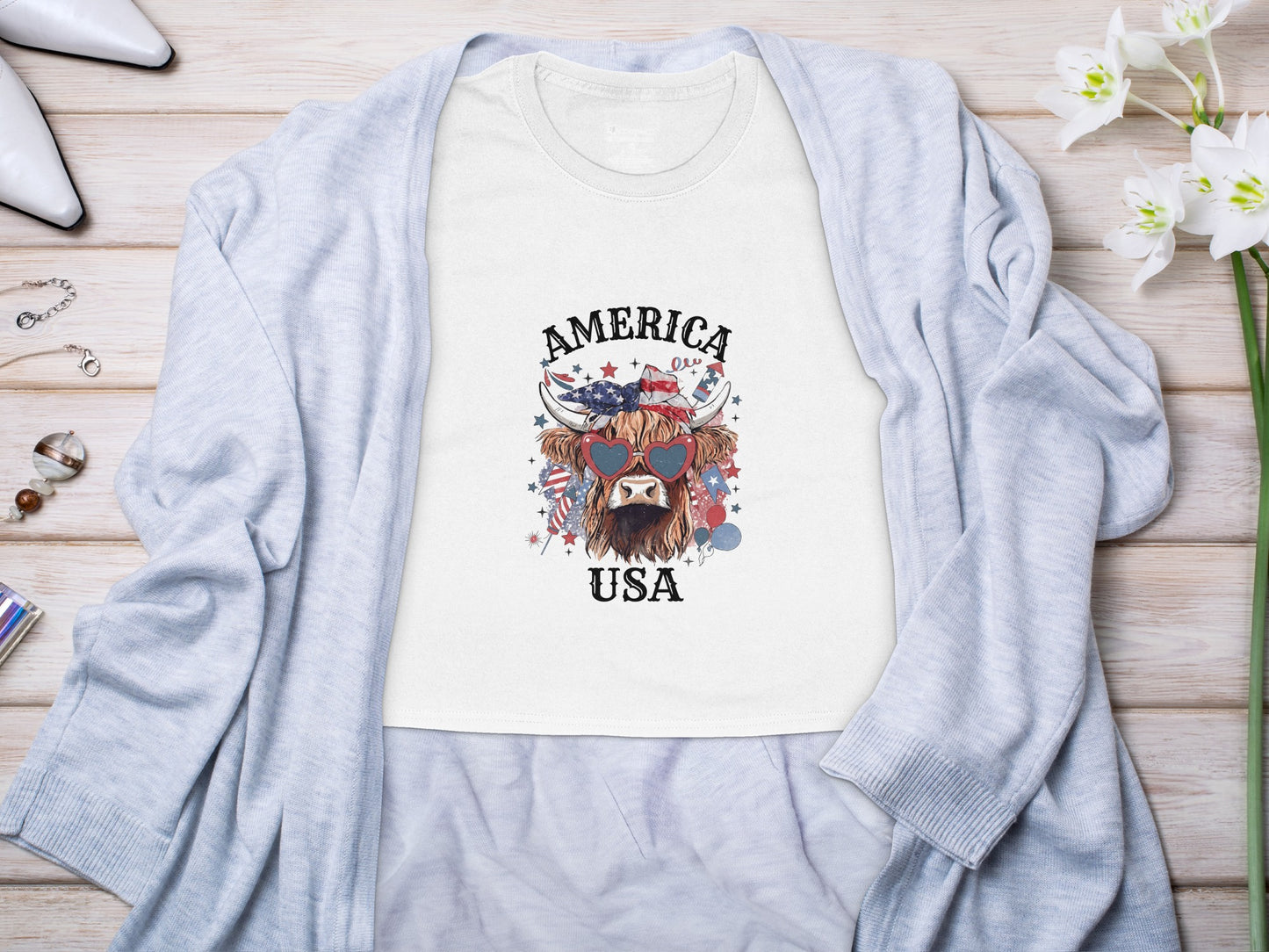 White t-shirt with Highland cow wearing heart sunglasses and "America USA" text.