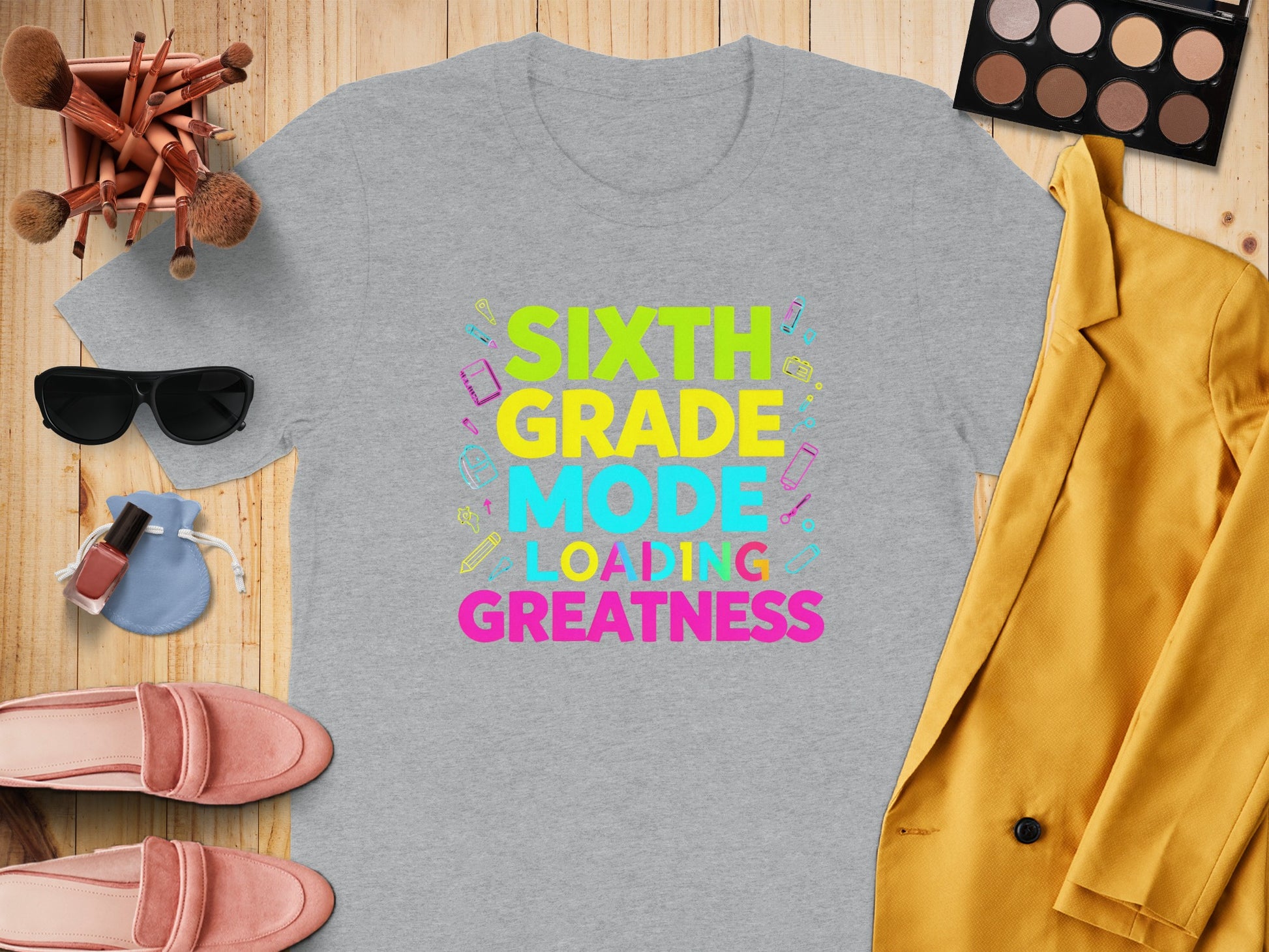 Grey t-shirt with "Sixth Grade Mode Loading Greatness" text and school supplies.