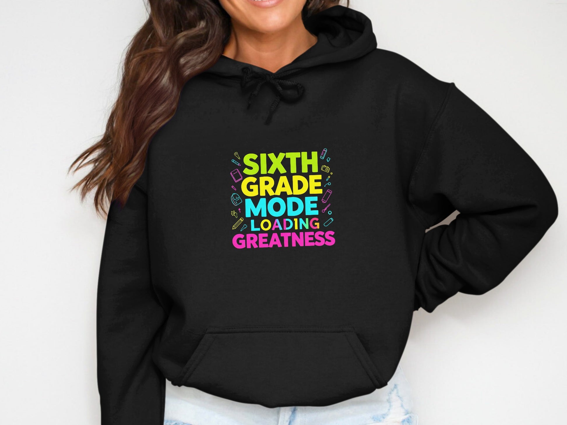 Black hoodie with "SIXTH GRADE MODE LOADING GREATNESS" text and school supplies graphics.