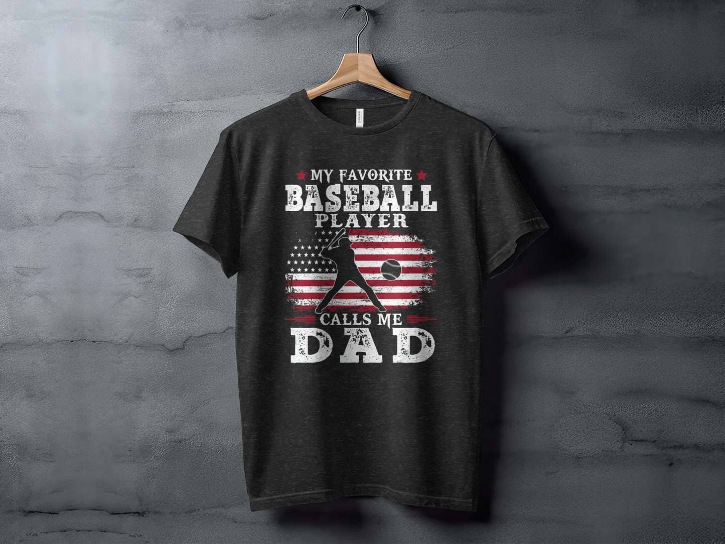 Dark gray t-shirt with "My Favorite Baseball Player Calls Me Dad" and American flag graphic.
