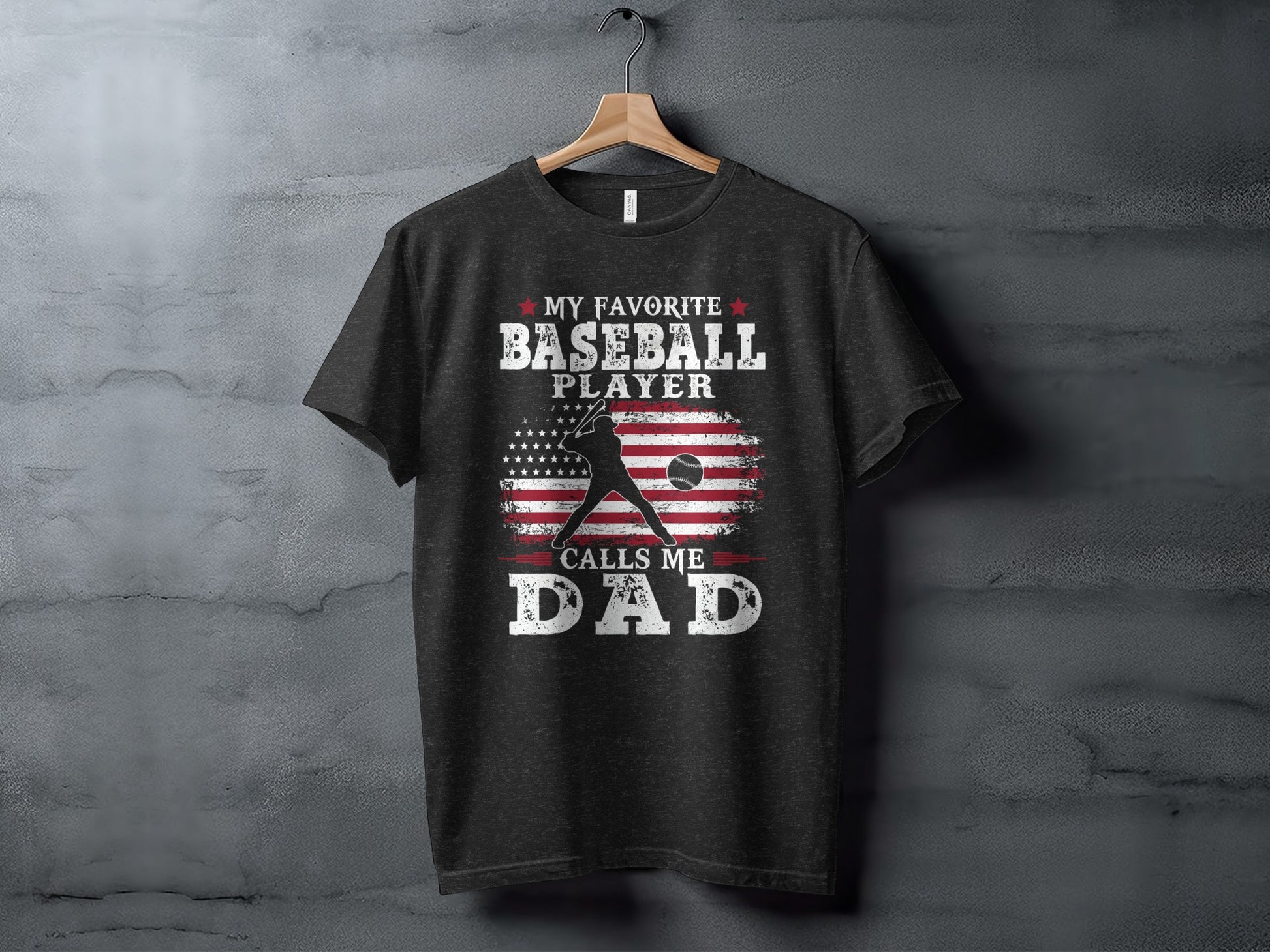 Dark gray t-shirt with "My Favorite Baseball Player Calls Me Dad" and American flag graphic.