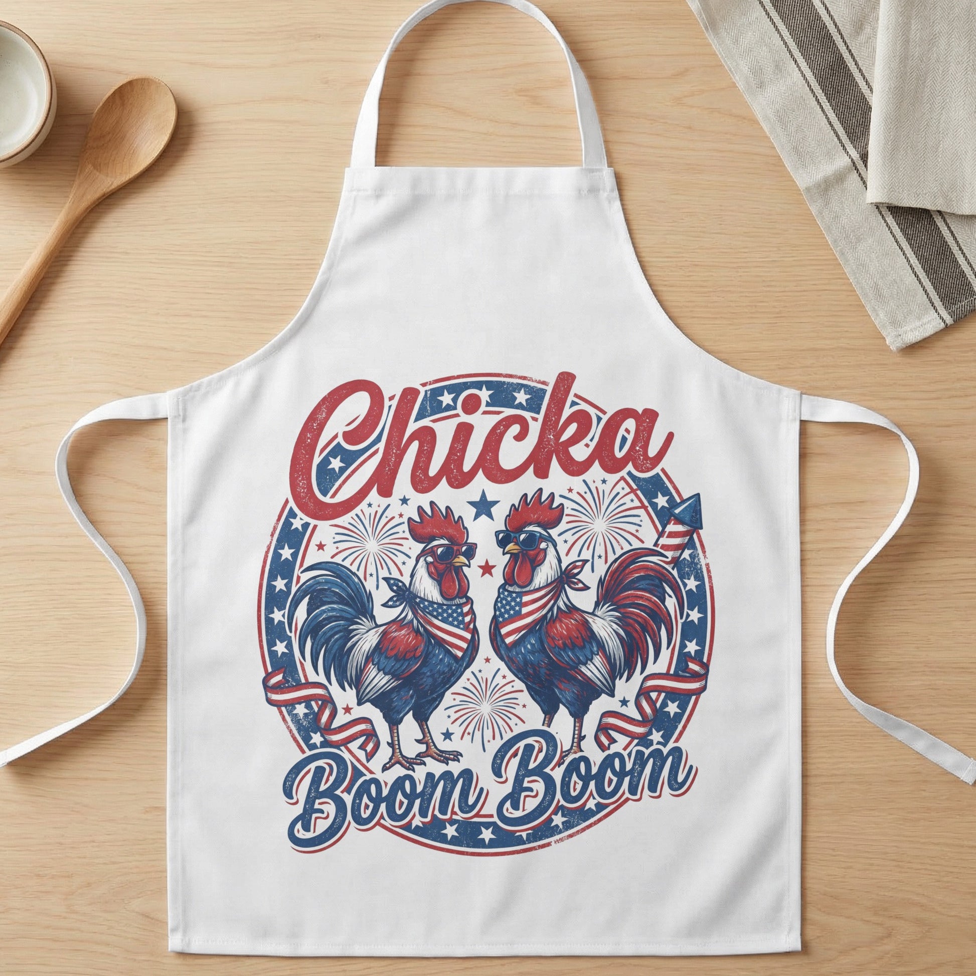 White apron with roosters wearing sunglasses and American flag bandanas, text "Chicka Boom Boom".
