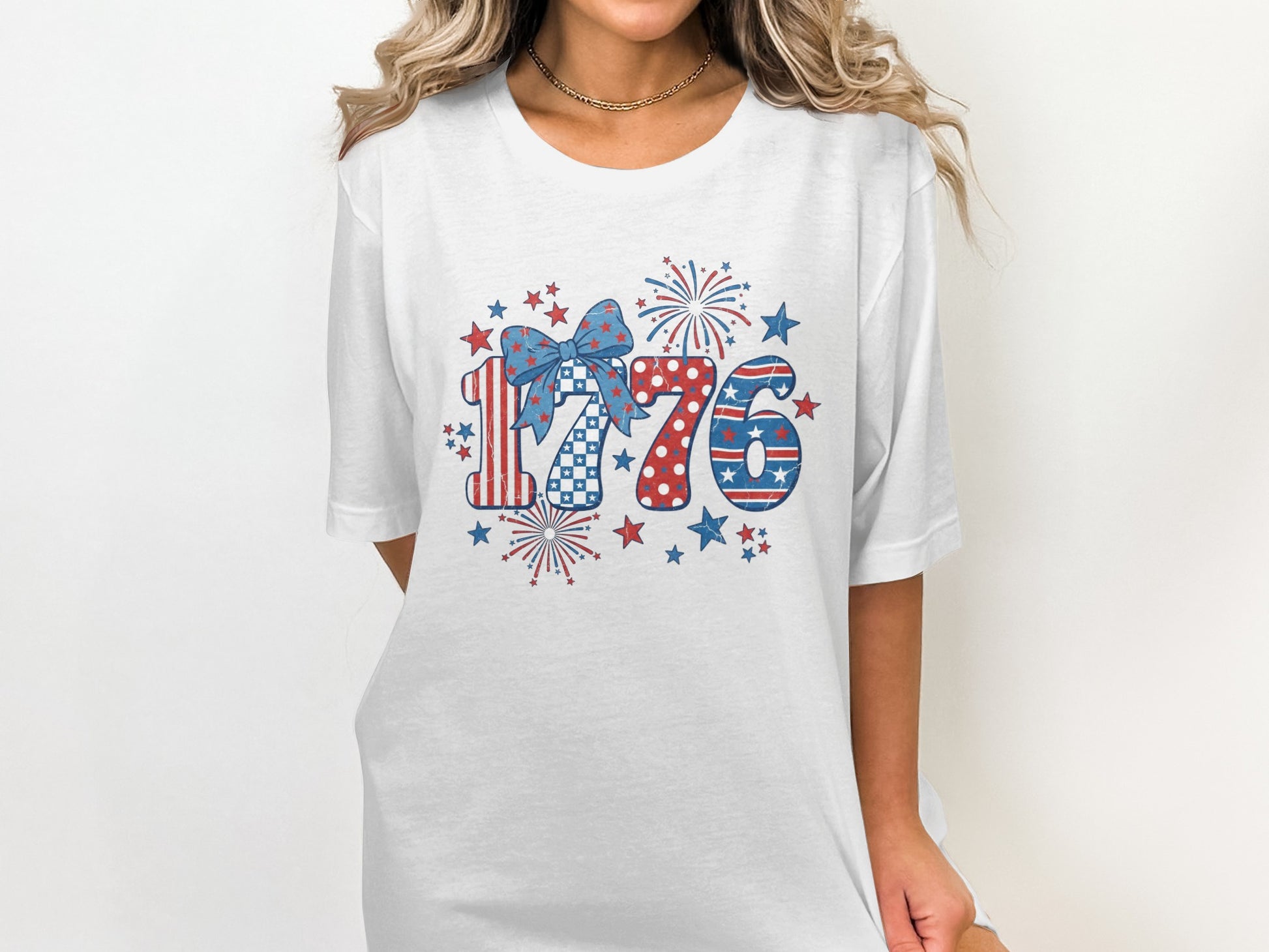 White t-shirt with red, white, and blue "1776" design and fireworks.