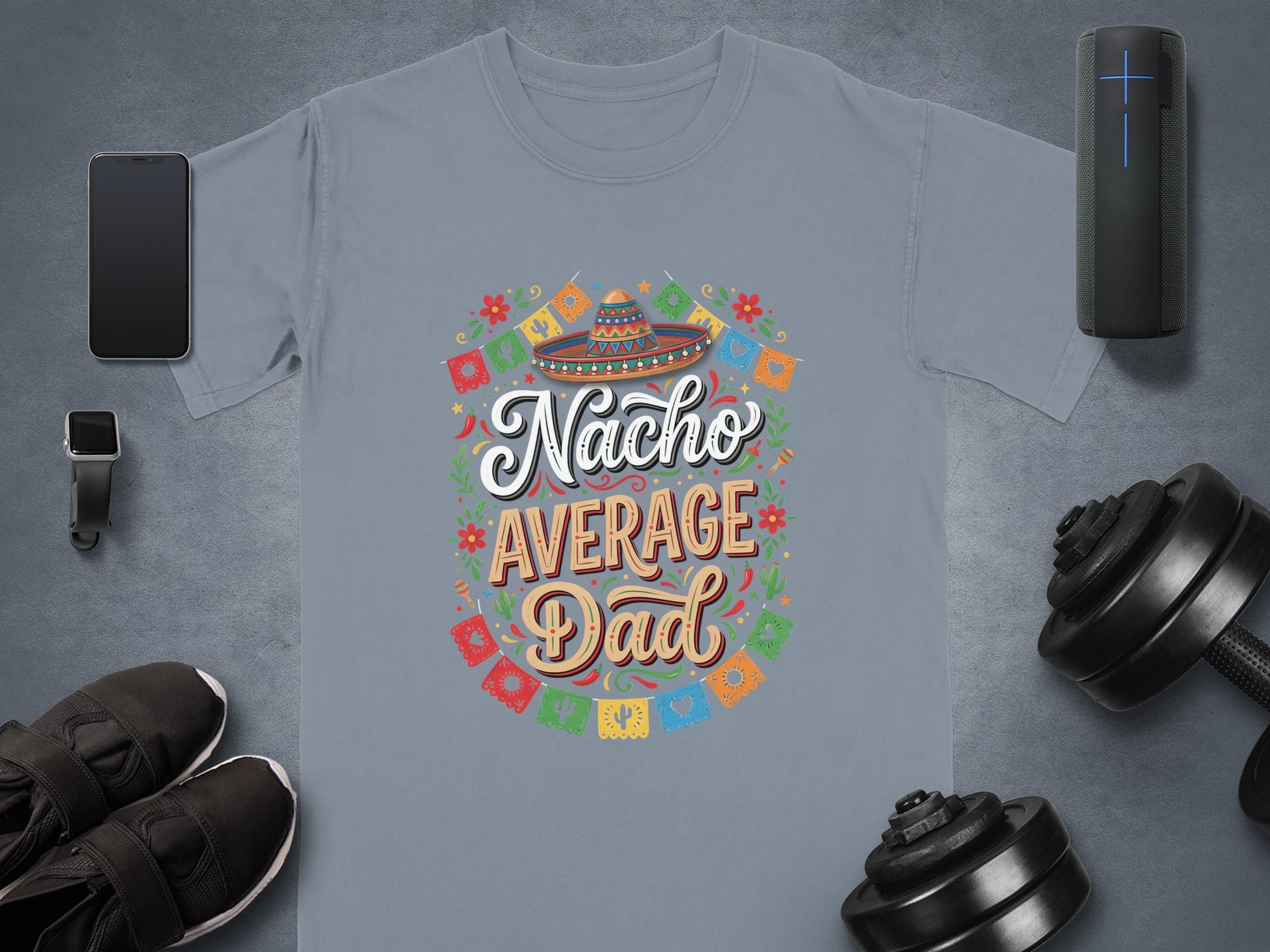 Gray t-shirt with "Nacho Average Dad" text, festive border, and surrounding fitness items.