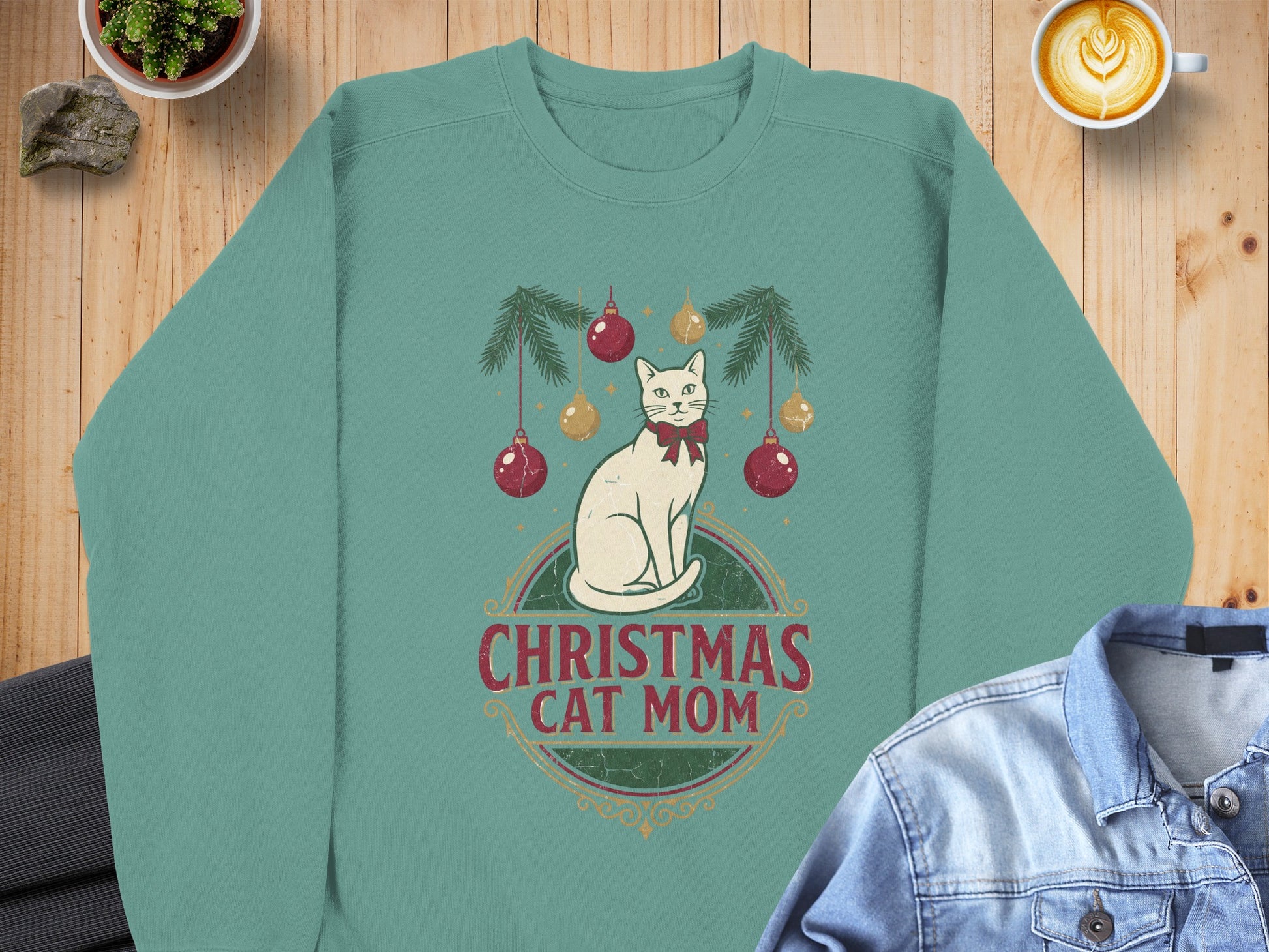 Teal sweatshirt with white cat and Christmas ornaments graphic that says "Christmas Cat Mom".