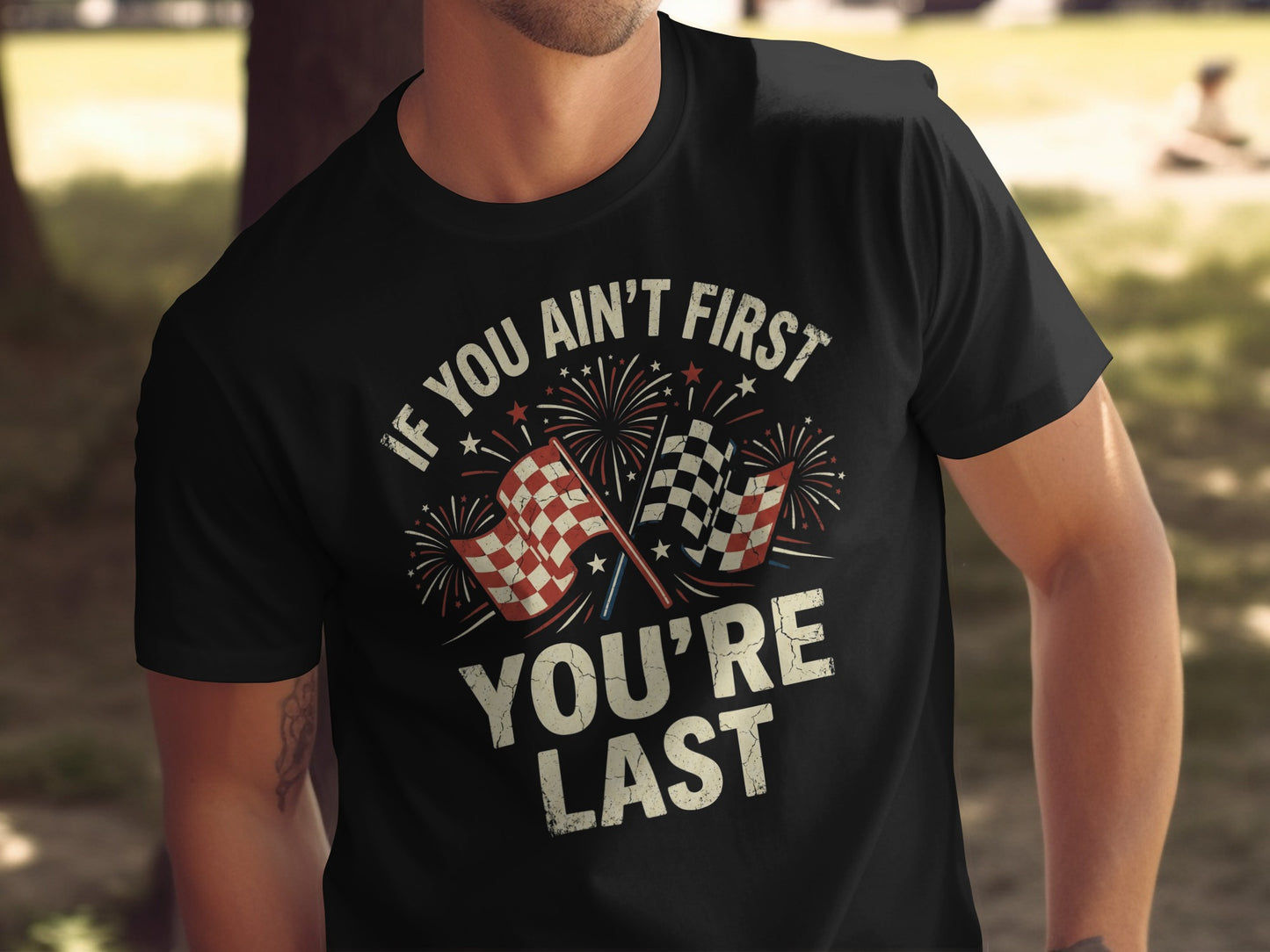 Black t-shirt with racing flags, fireworks, and text "IF YOU AIN'T FIRST YOU'RE LAST".