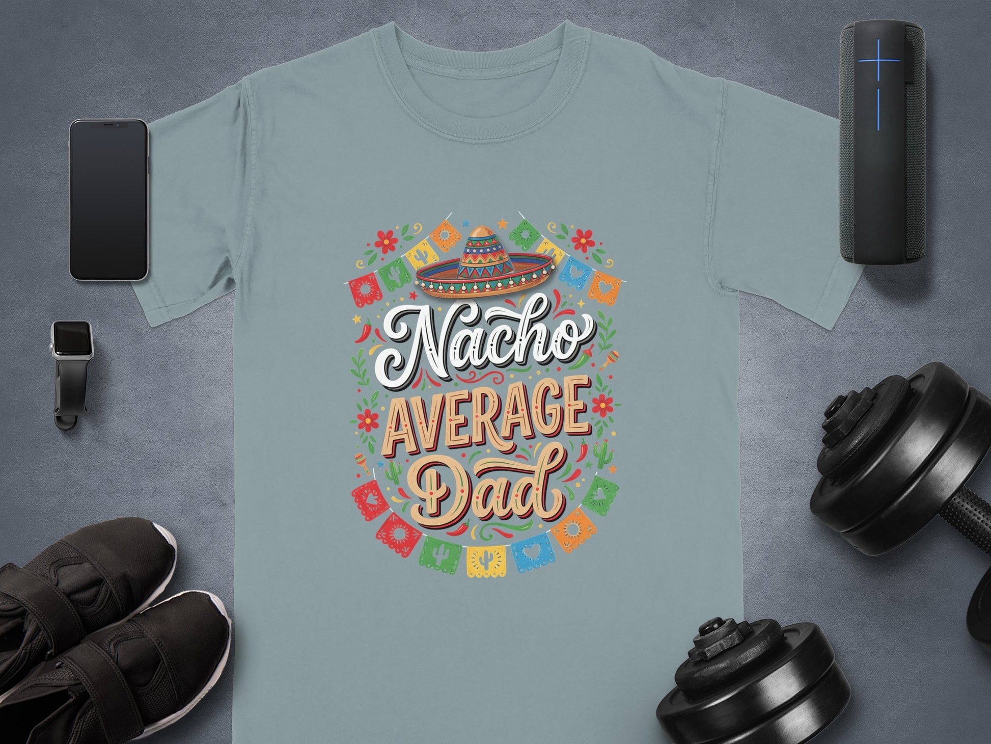 "Nacho Average Dad" text and colorful graphic on a grey t-shirt with fitness accessories.