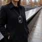 Woman wearing the 9/11 white rose memorial dog tag necklace beside a memorial reflecting pool
