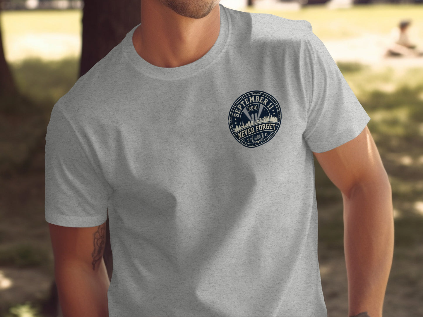 Grey t-shirt with "September 11 2001 Never Forget" badge design.
