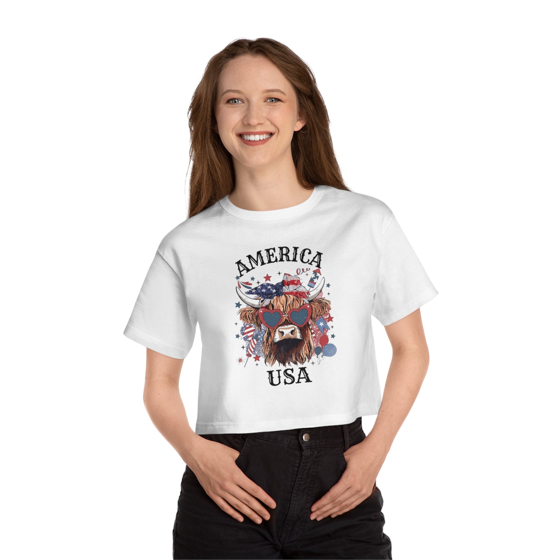 White crop top with a Highland cow graphic wearing patriotic accessories and USA text.
