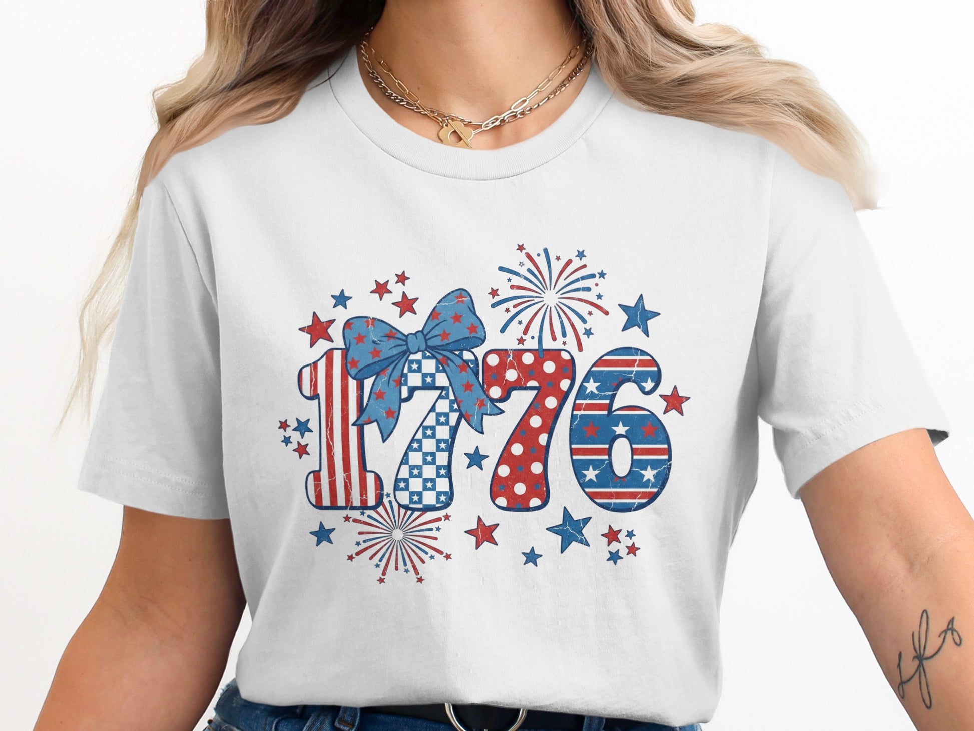 White t-shirt with patriotic "1776" design featuring stars, stripes, and fireworks.