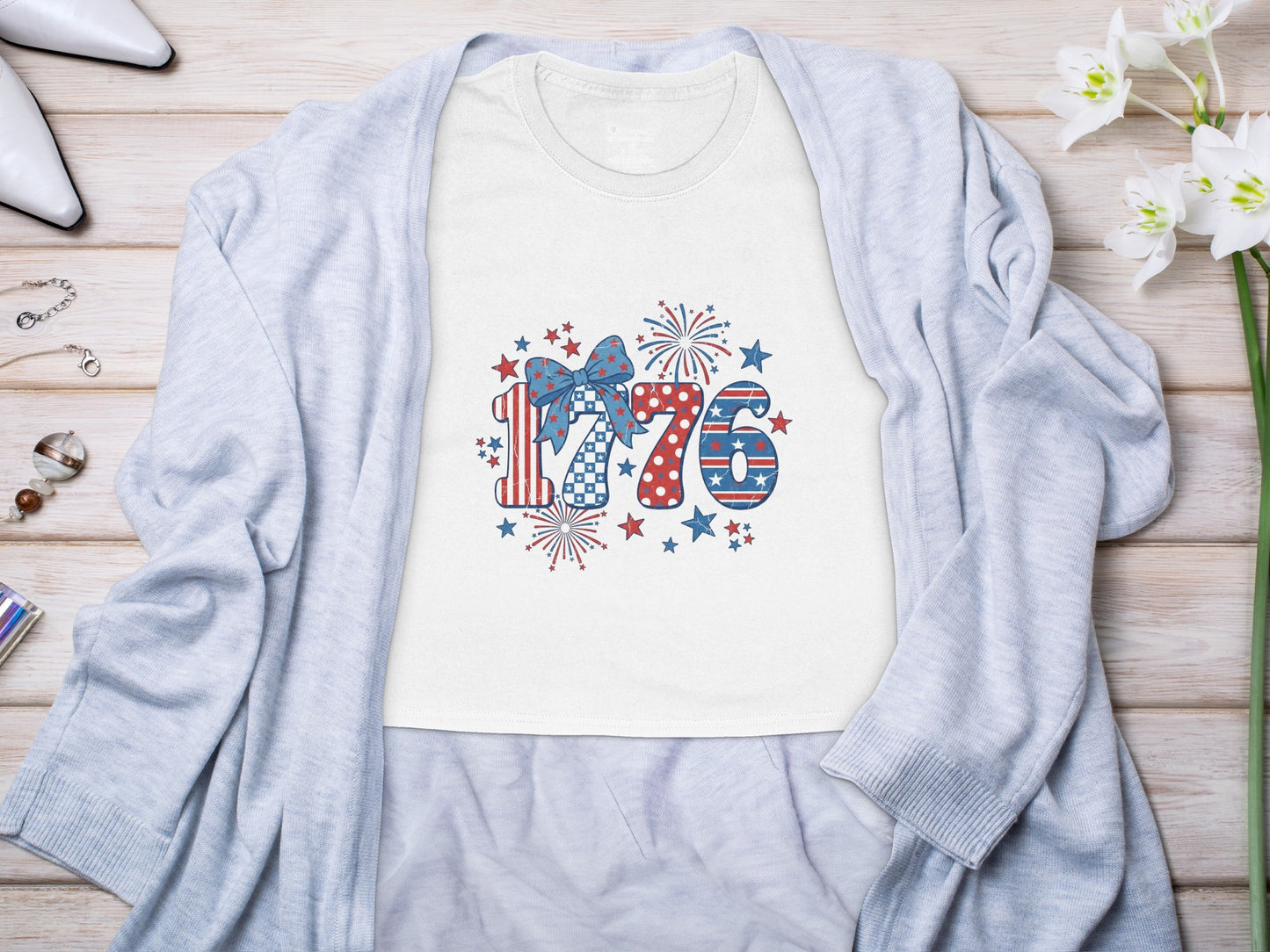White t-shirt with "1776" graphic featuring patriotic patterns, stars, and fireworks.