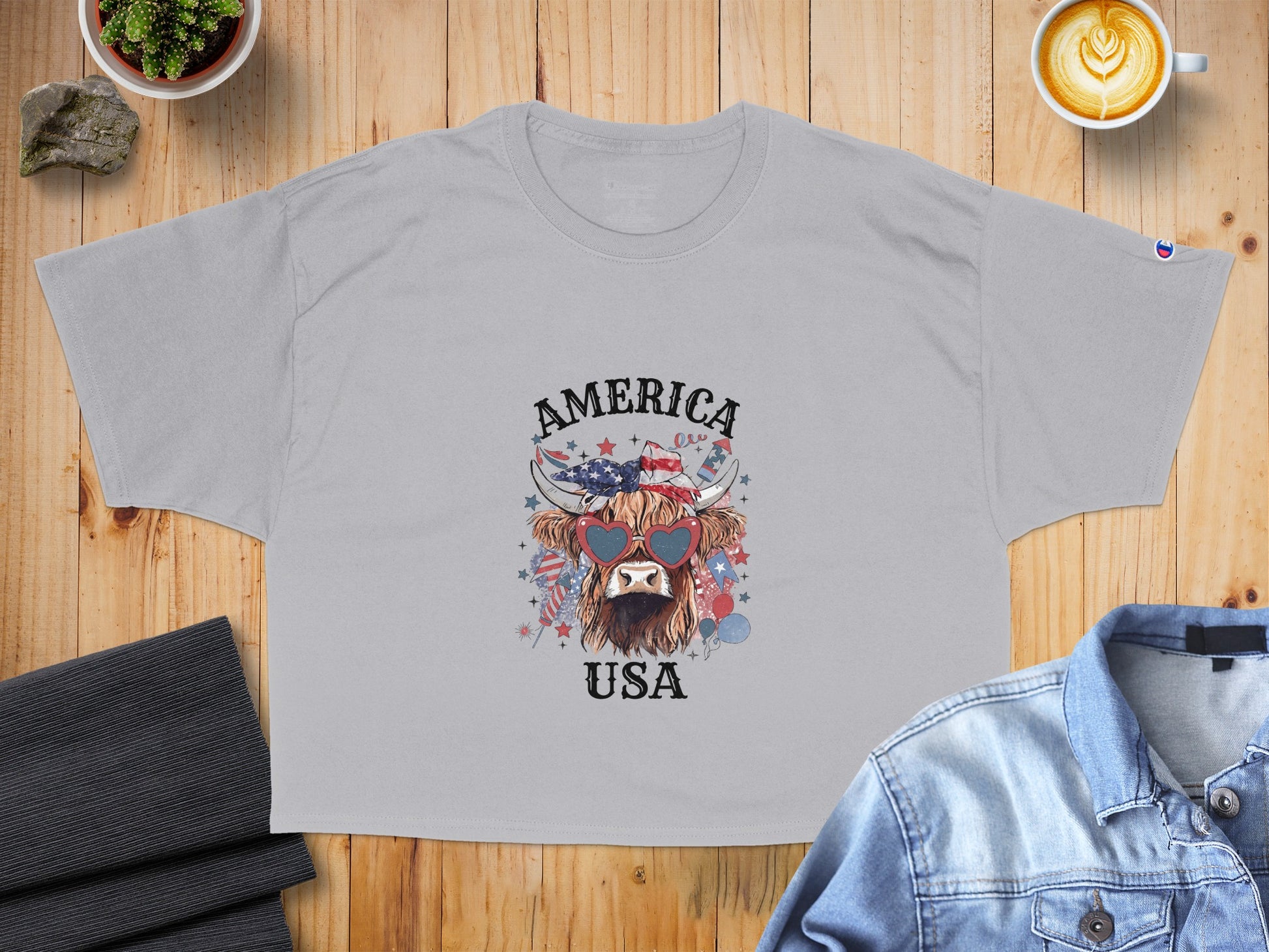 Gray t-shirt with a Highland cow wearing heart-shaped sunglasses and "AMERICA USA" text.