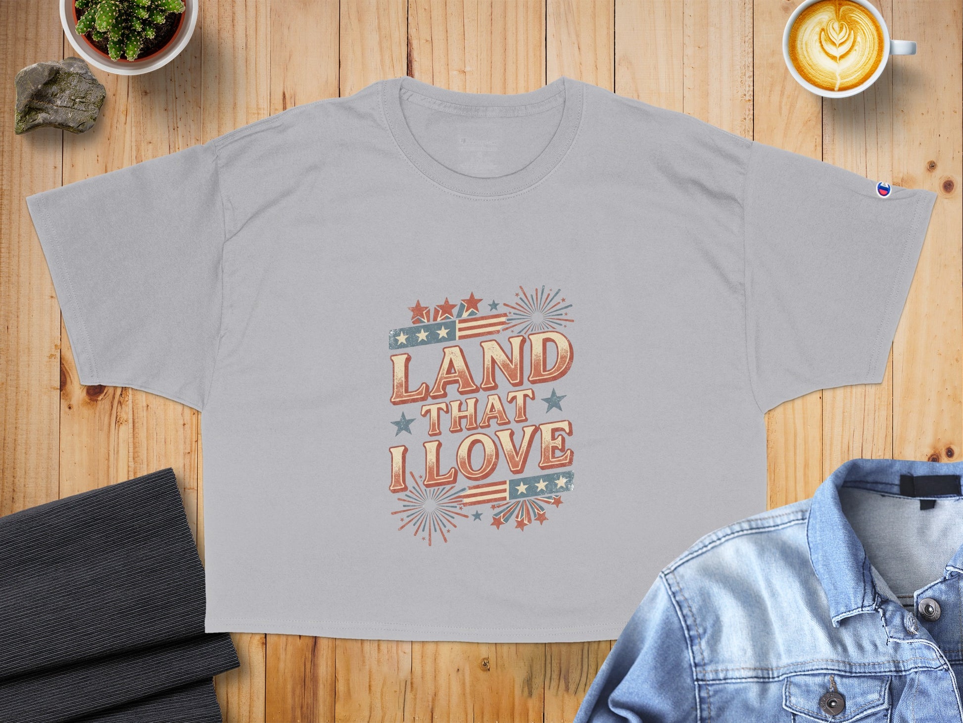 Gray t-shirt with "Land That I Love" graphic featuring American flag elements.