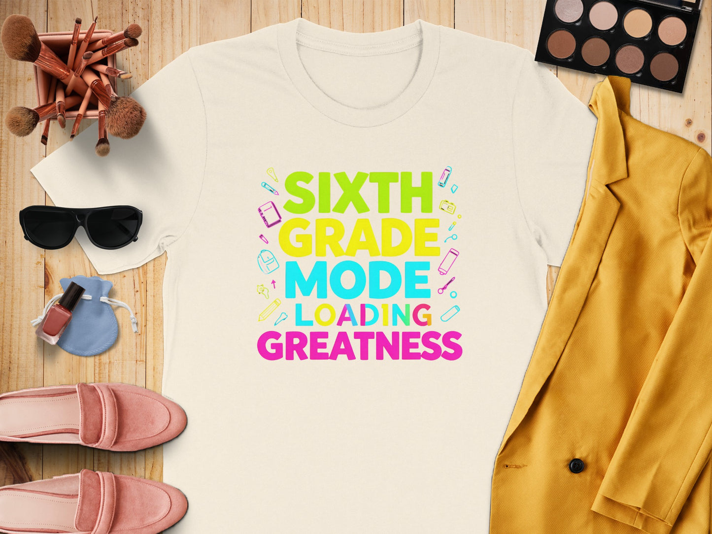 T-shirt with "Sixth Grade Mode Loading Greatness" text and school supplies graphics.