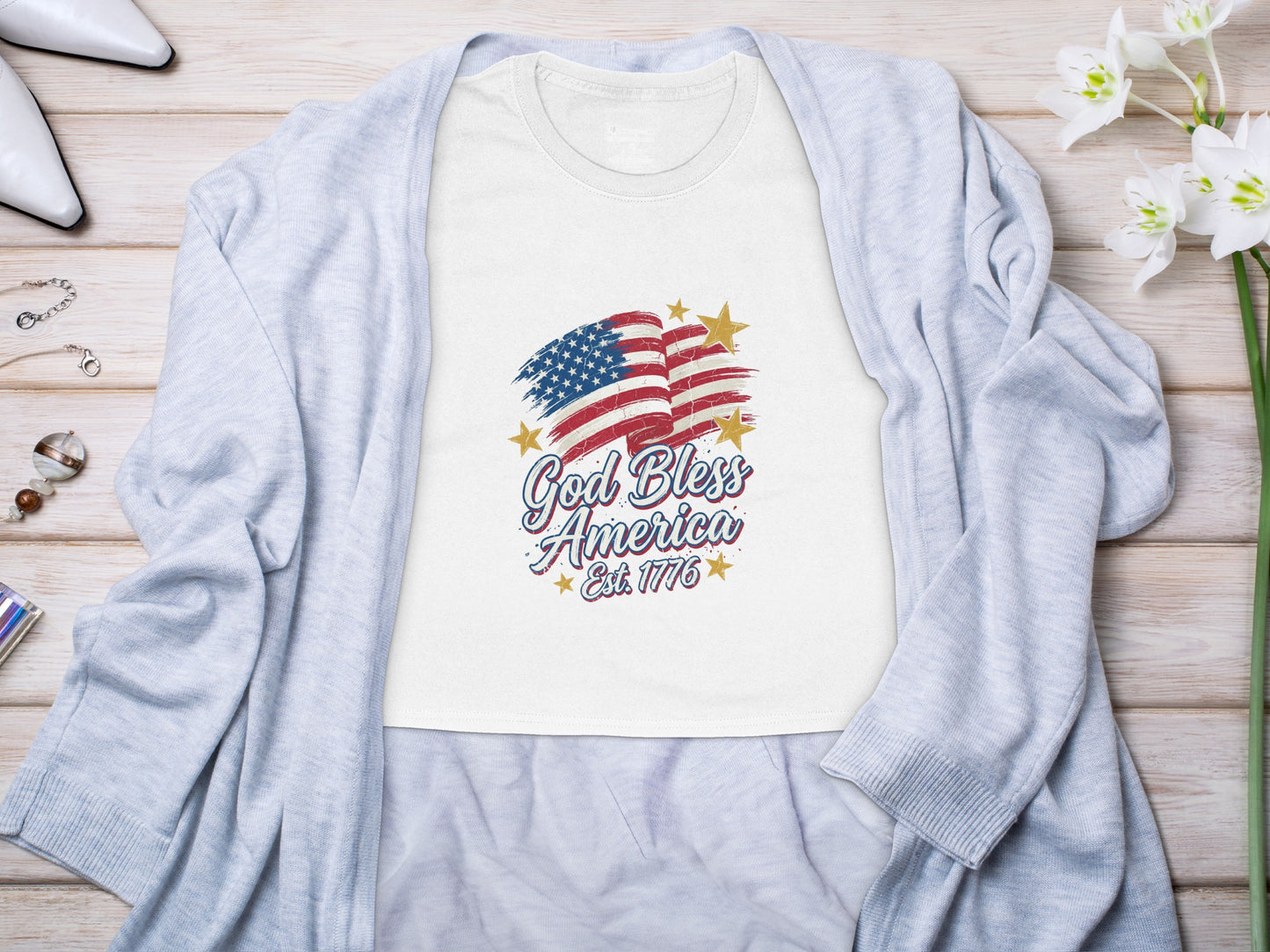 White t-shirt with American flag graphic and "God Bless America Est. 1776" text.