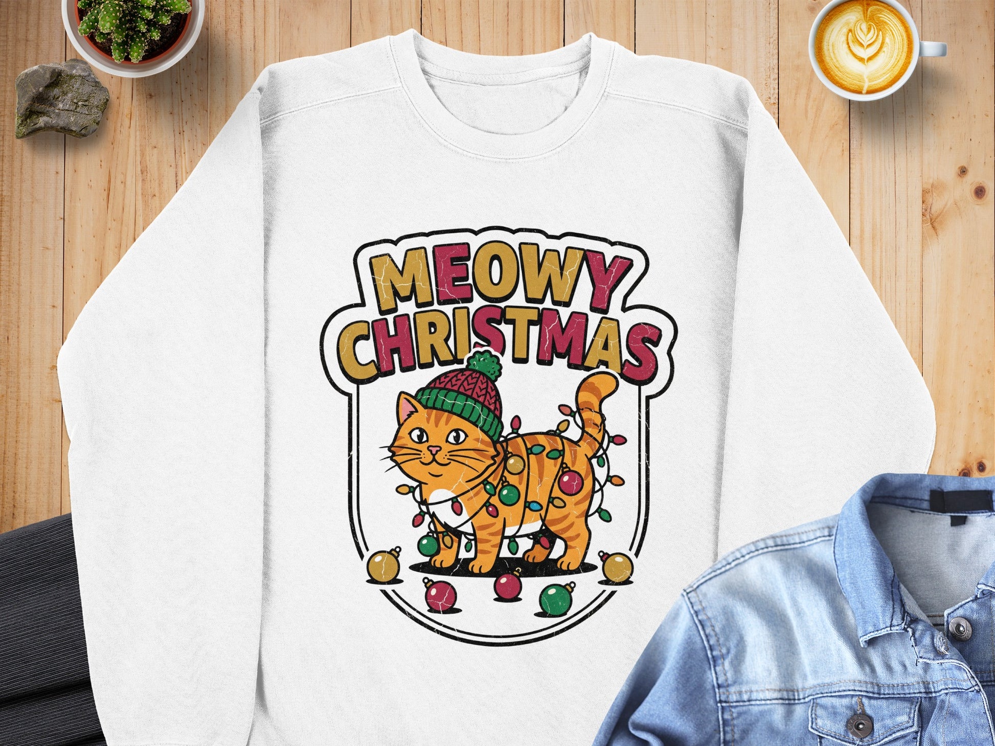 White sweatshirt with a graphic of a cat tangled in Christmas lights.
