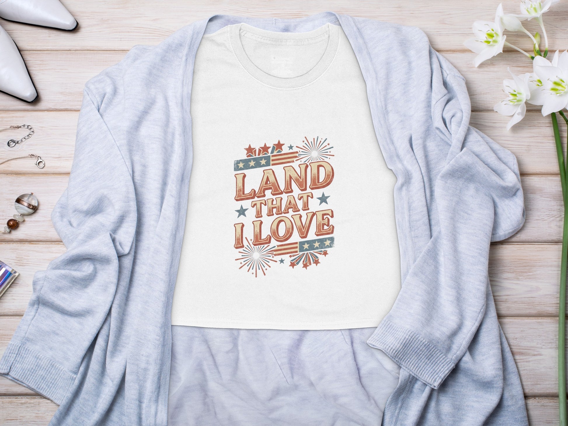 White t-shirt with "Land That I Love" patriotic graphic design.