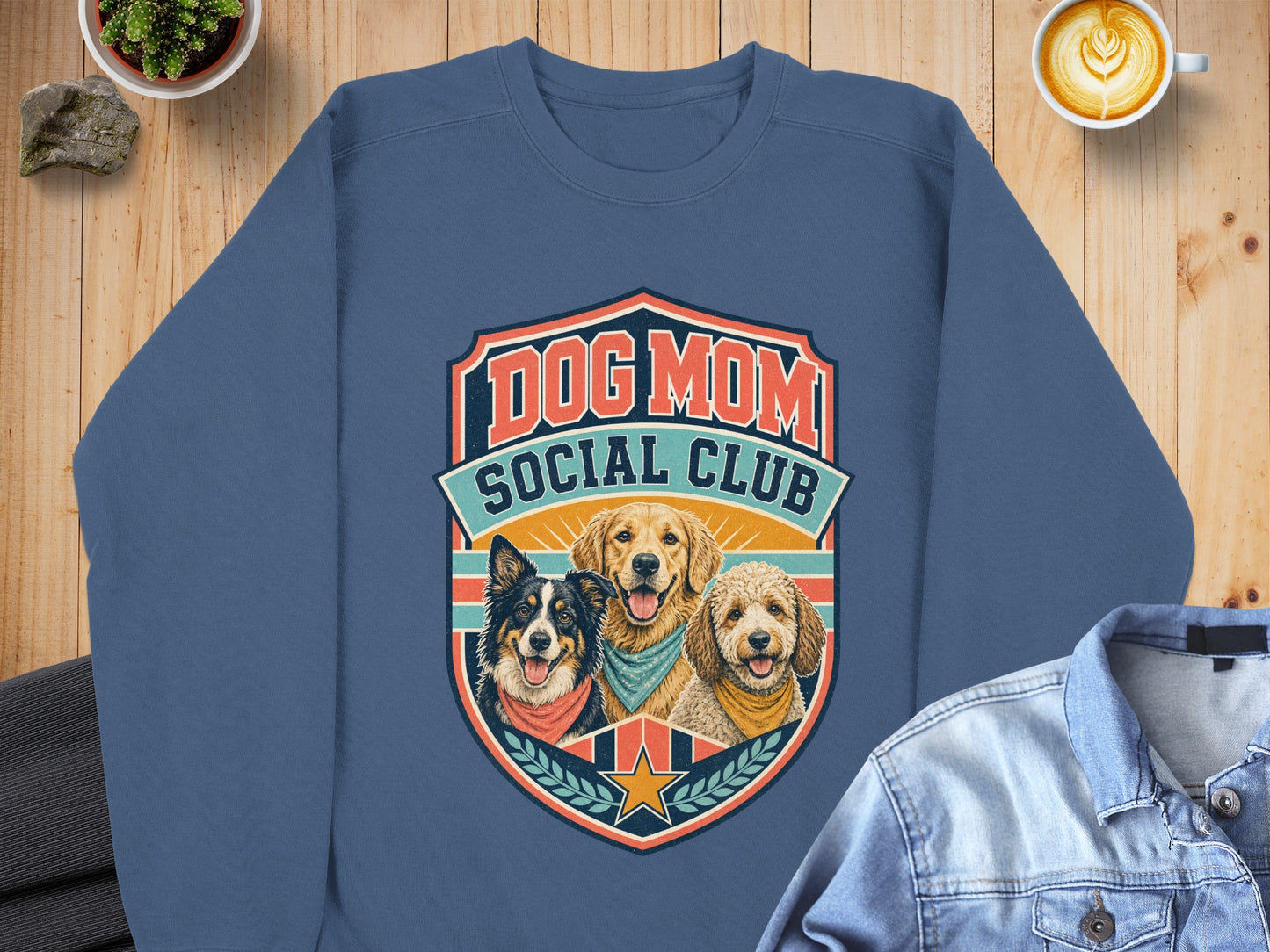 Blue sweatshirt with "Dog Mom Social Club" and three dogs in a shield graphic.