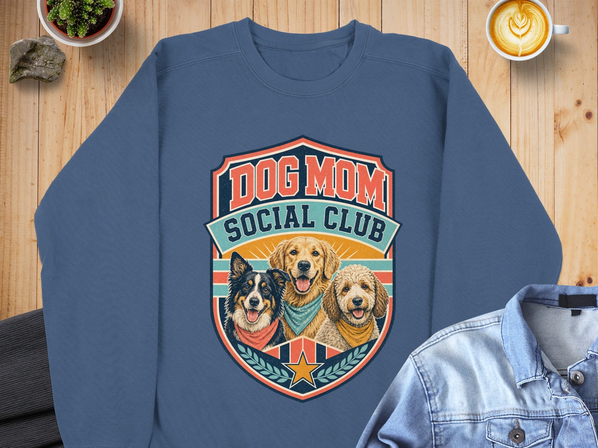 Blue sweatshirt with "Dog Mom Social Club" and three dogs in a shield graphic.