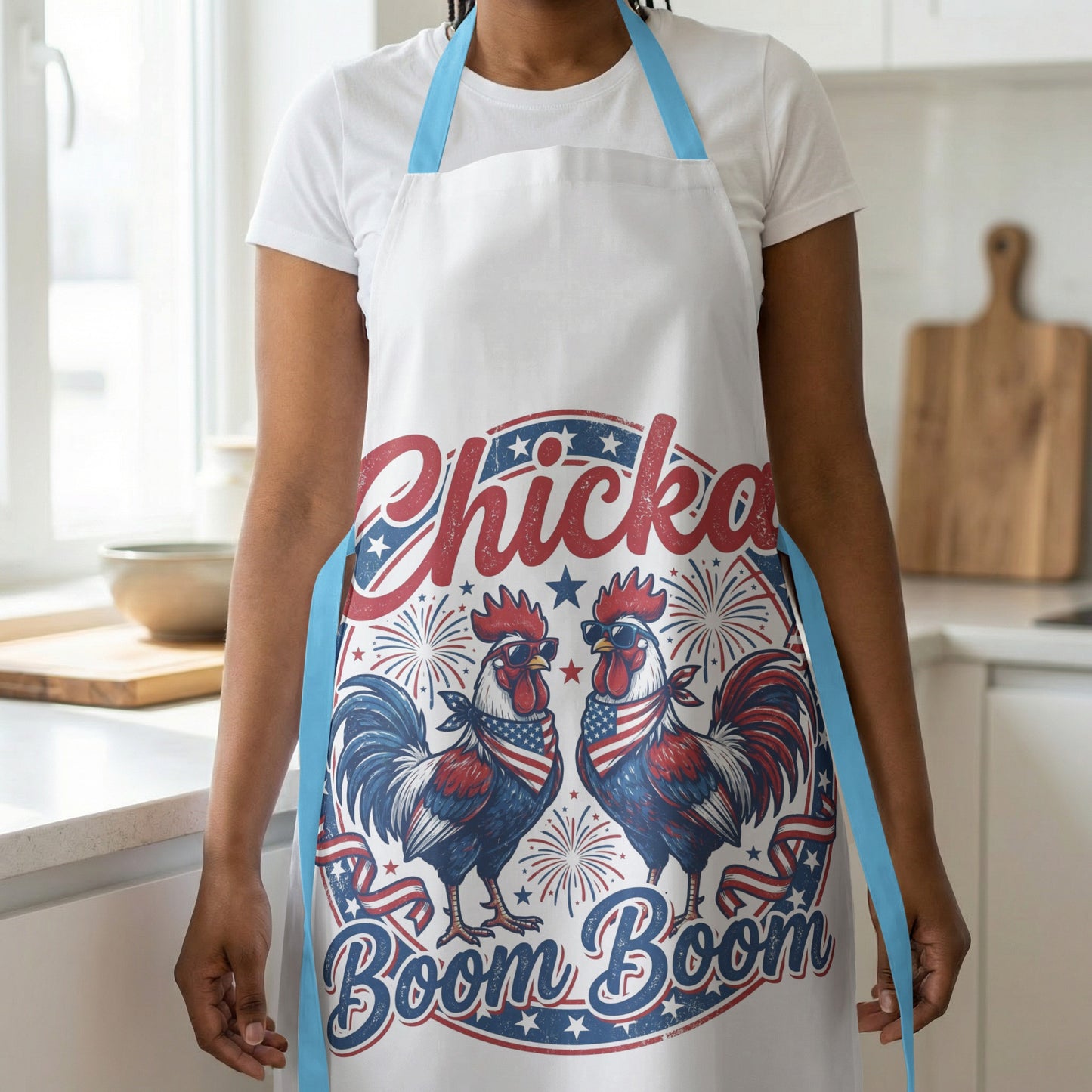 White apron with patriotic roosters saying "Chicke Boom Boom."