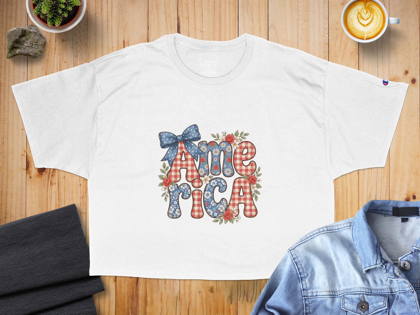 White t-shirt with "America" text featuring patriotic floral and gingham patterns.