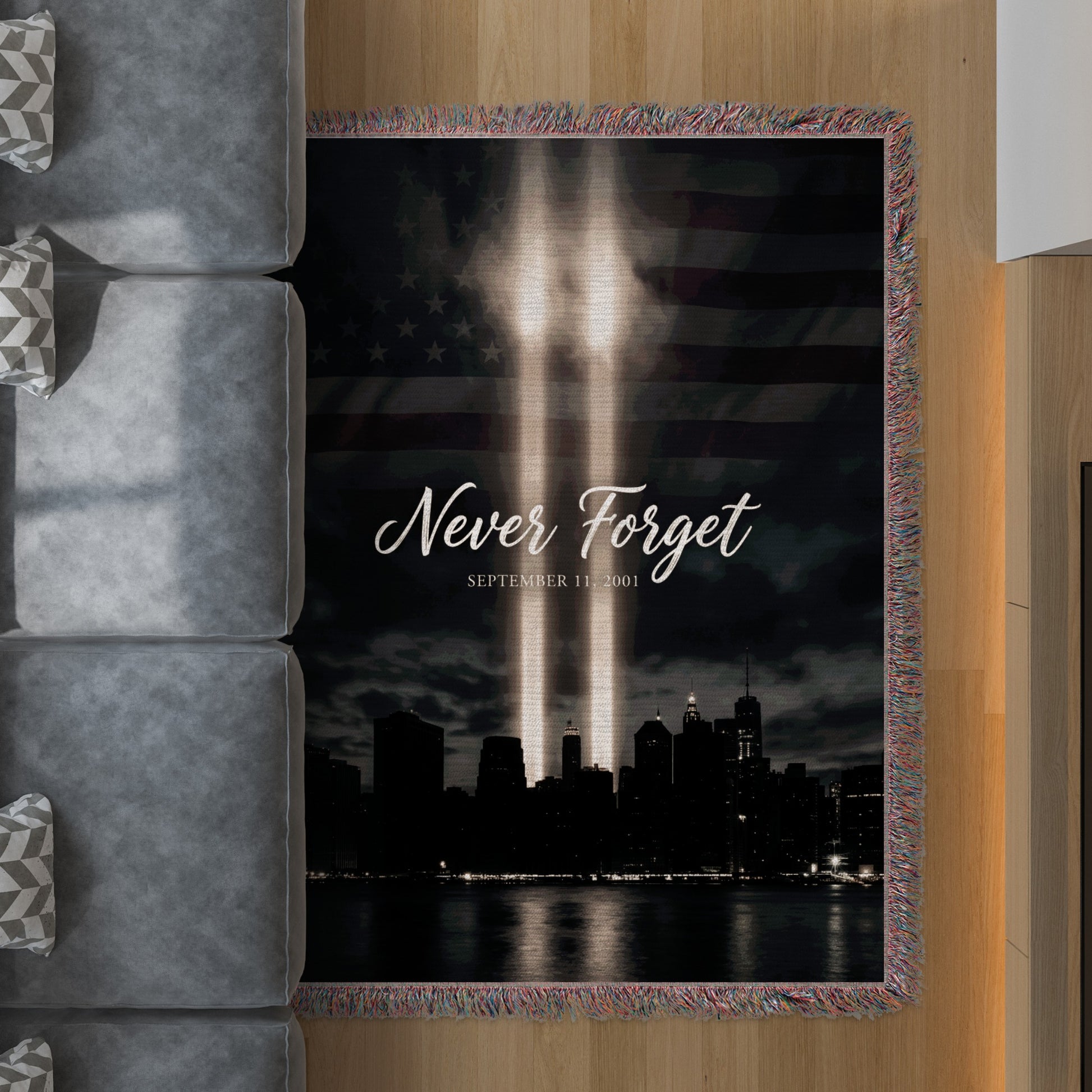 Tribute blanket with Twin Towers lights, flag background, and "Never Forget September 11, 2001" text.