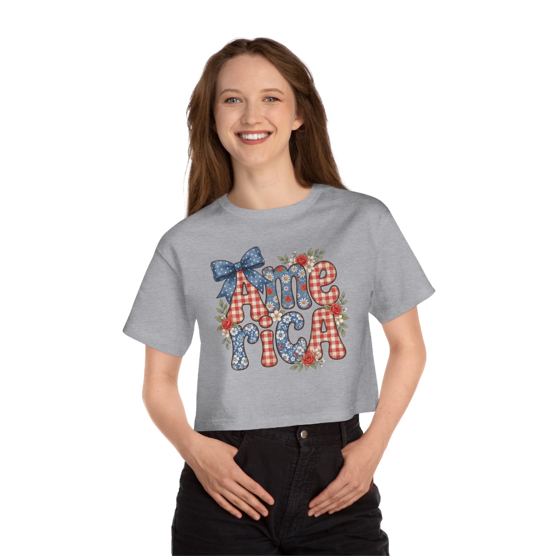Grey crop top with "AMERICA" text featuring patriotic patterns, flowers, and a bow.
