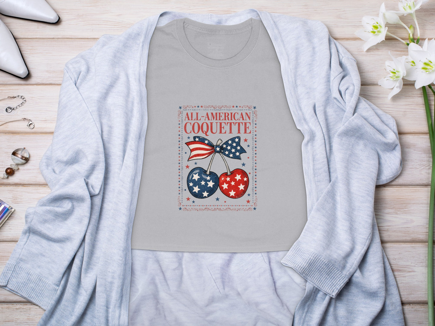 Grey t-shirt with "All-American Coquette" text, patriotic cherries and bow.